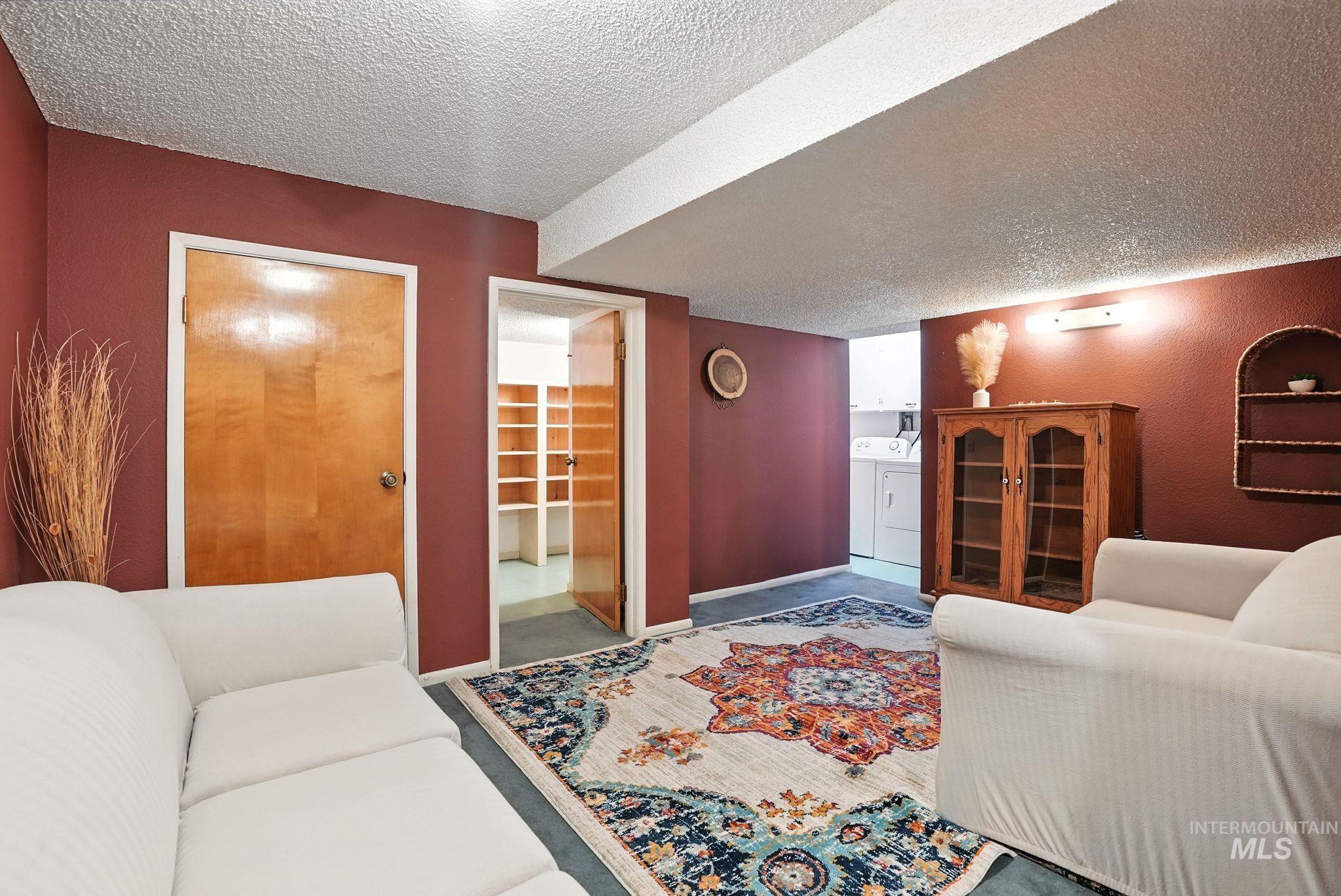 Living area featuring a textured ceiling and independent washer and dryer