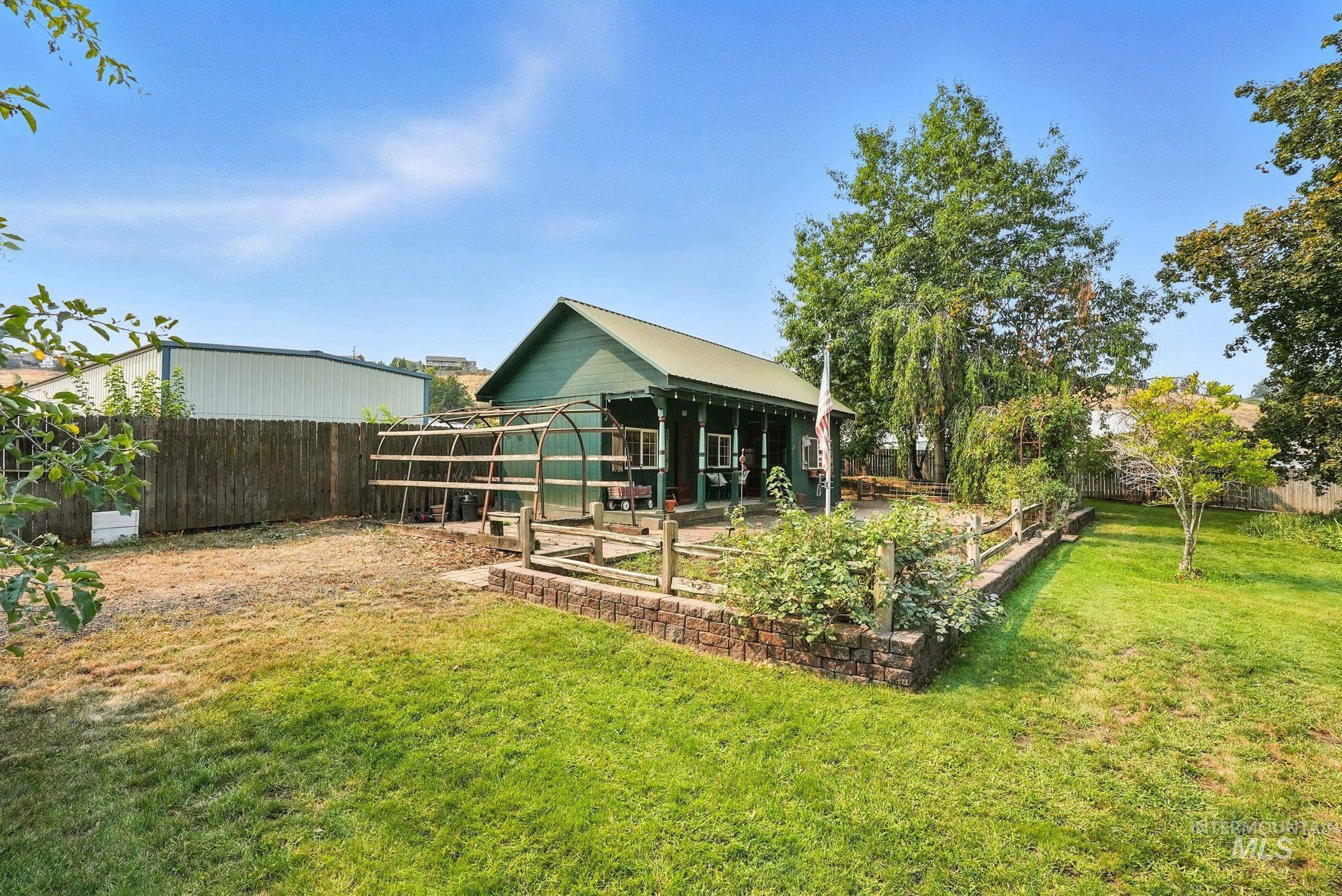 Fenced backyard with an outdoor structure and a patio area