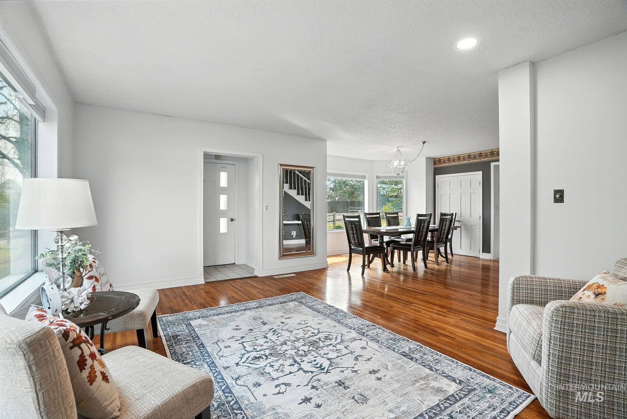 Living area with wood finished floors, a textured ceiling, recessed lighting, and a chandelier