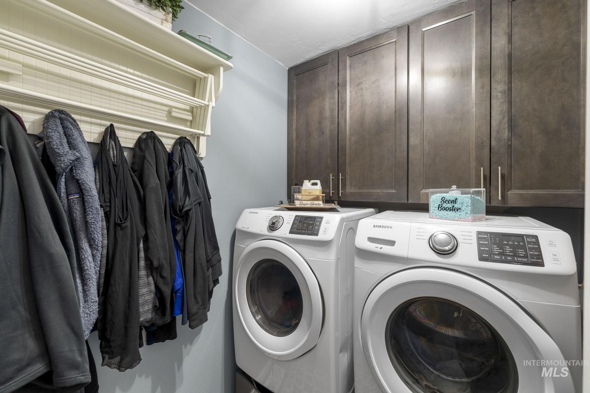 Laundry room featuring independent washer and dryer and cabinet space