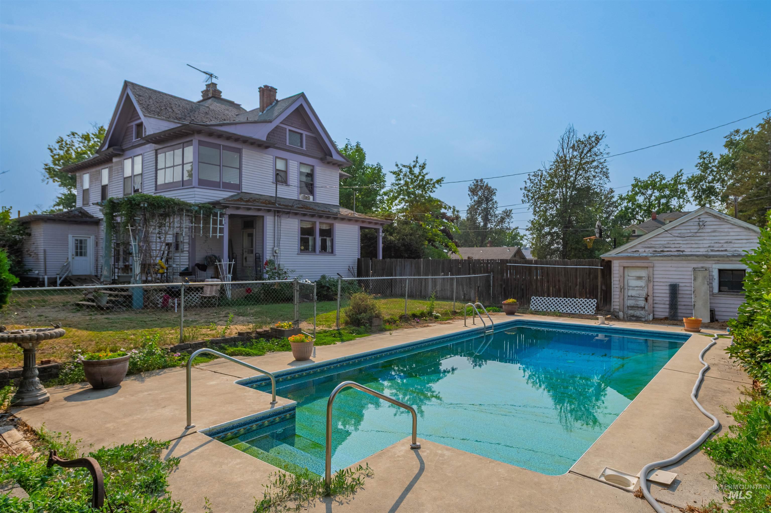 View of pool with a patio area, a fenced backyard, and an outdoor structure