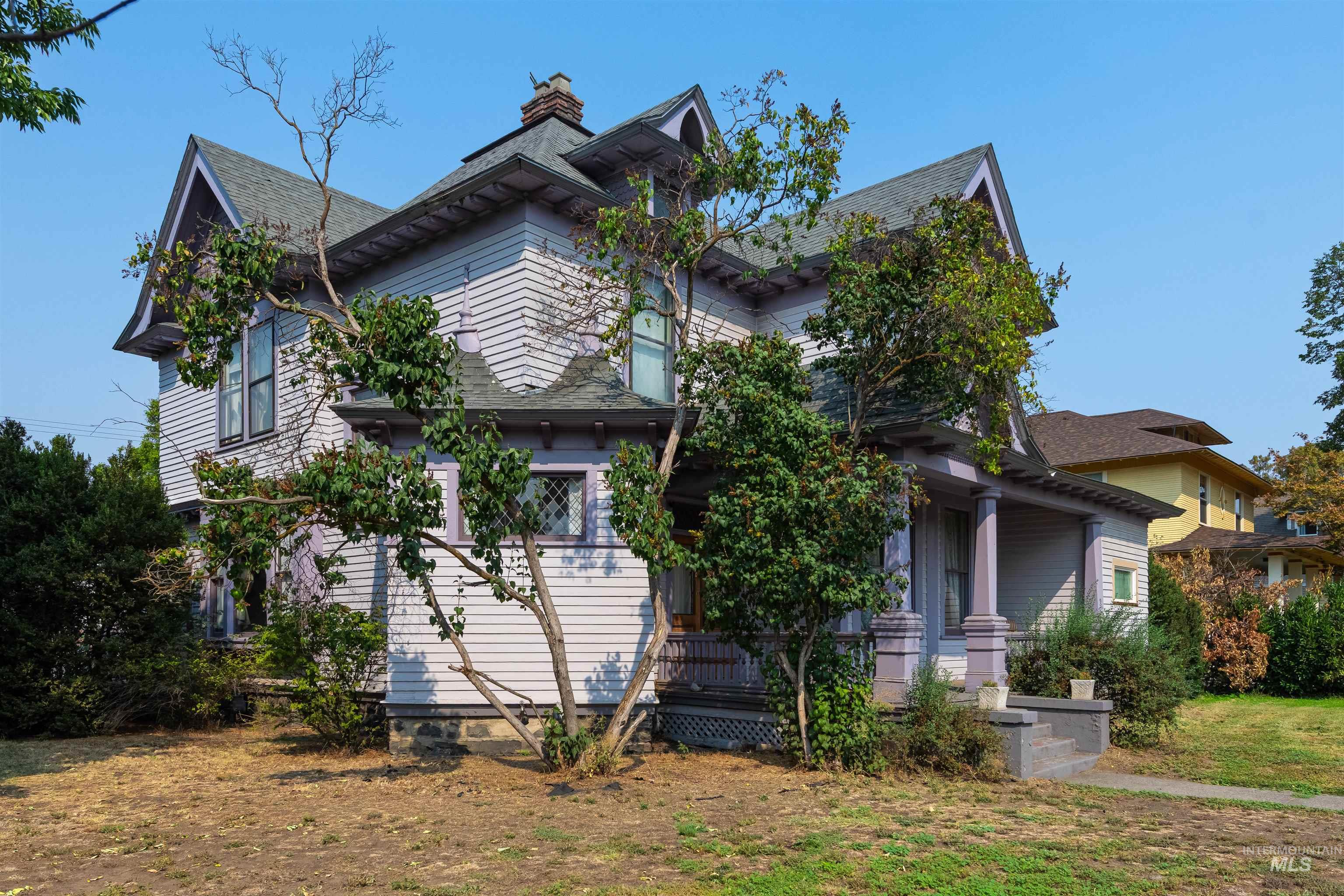 View of front of house featuring a chimney and a porch