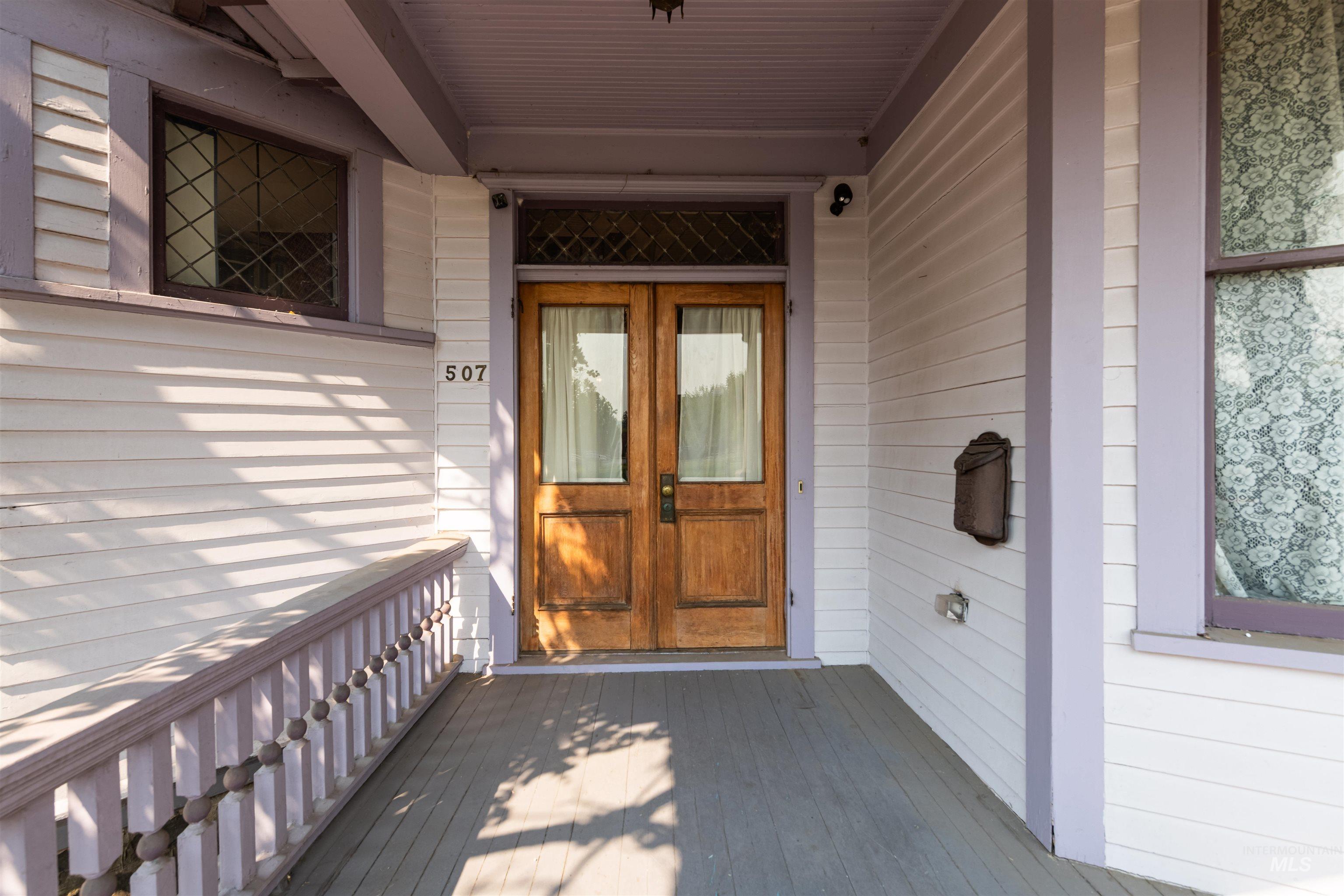 Property entrance featuring covered porch and french doors