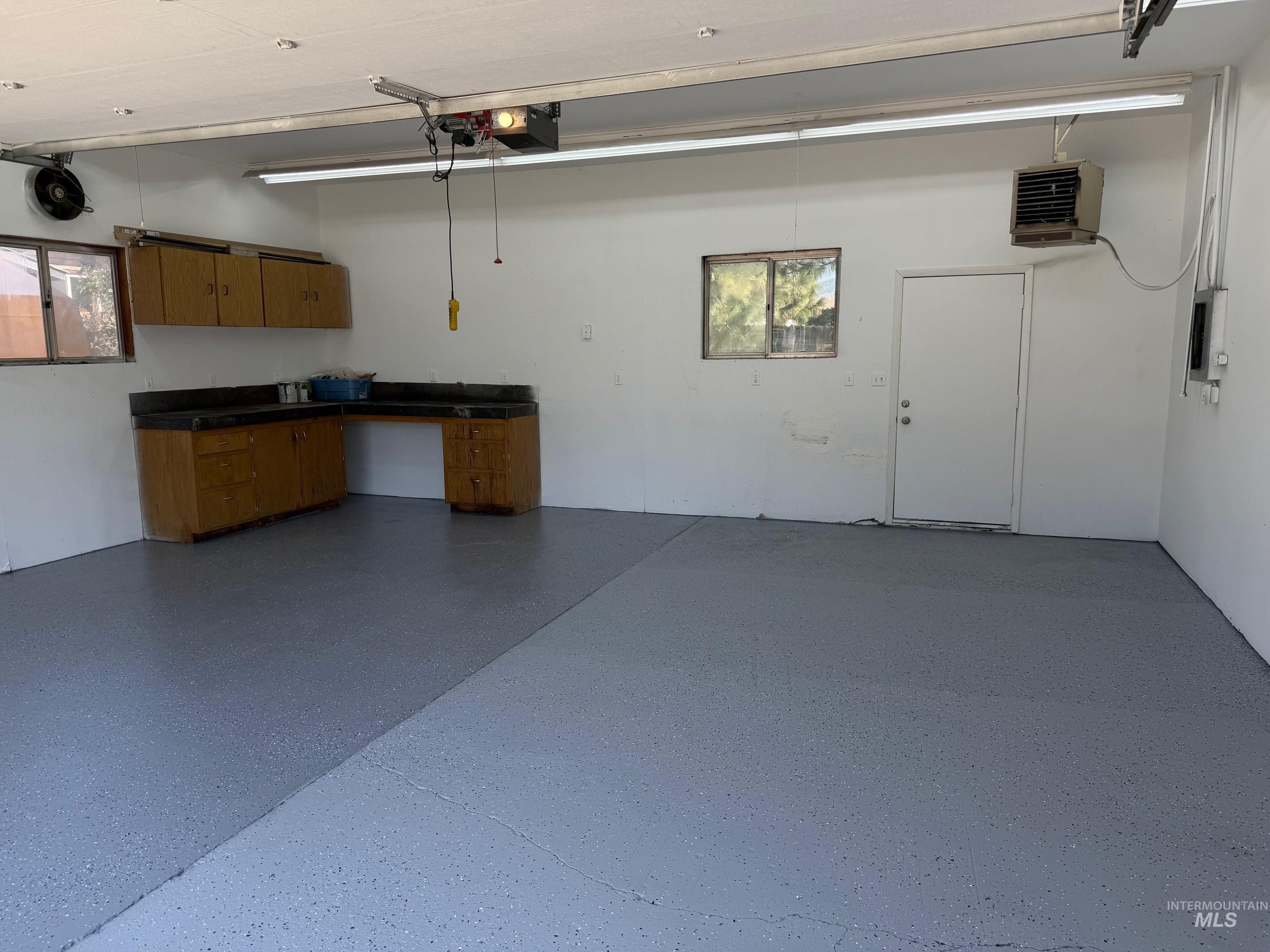 Garage featuring a heating unit and electric panel