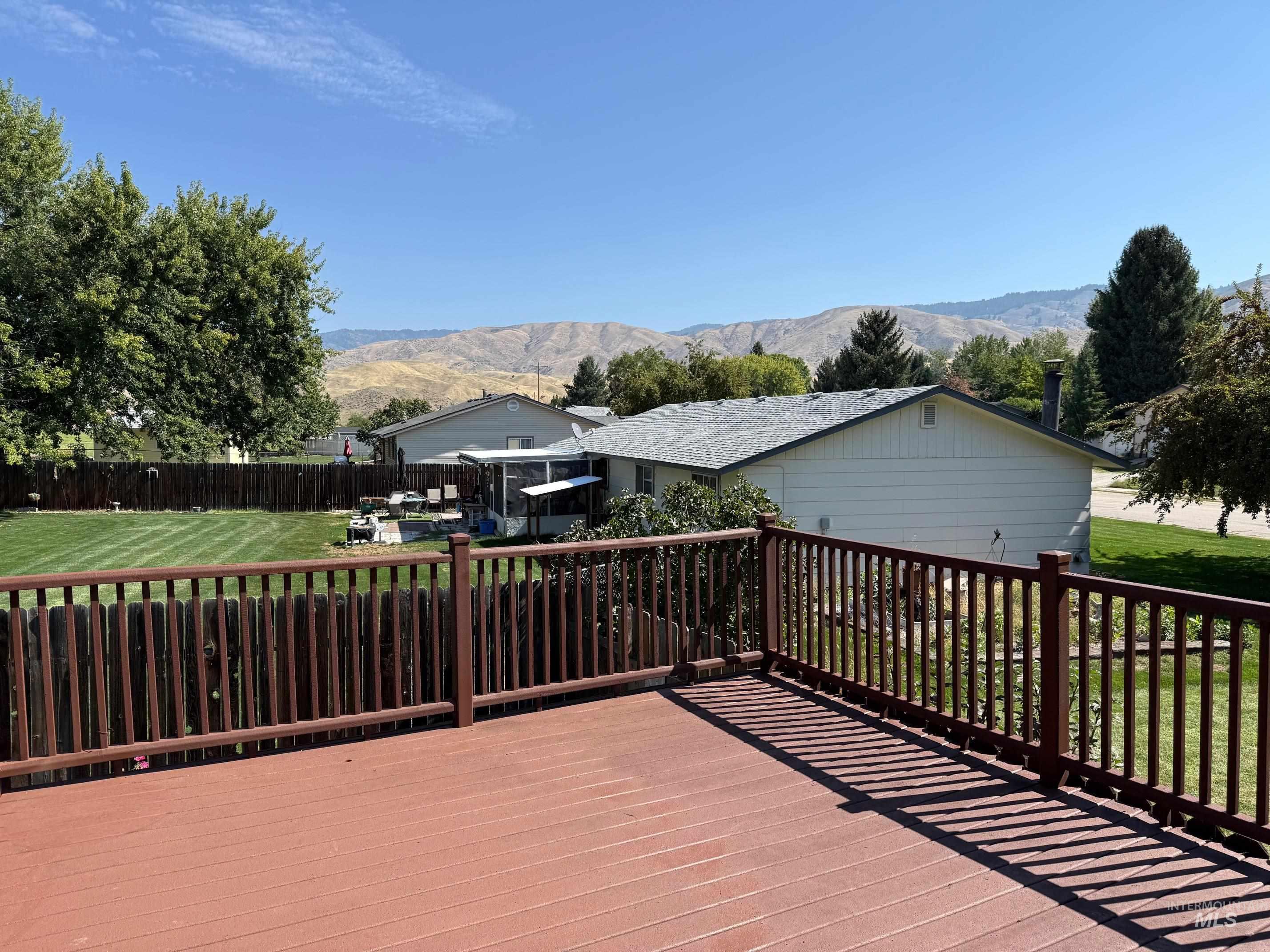 Wooden deck featuring a yard and a mountain view