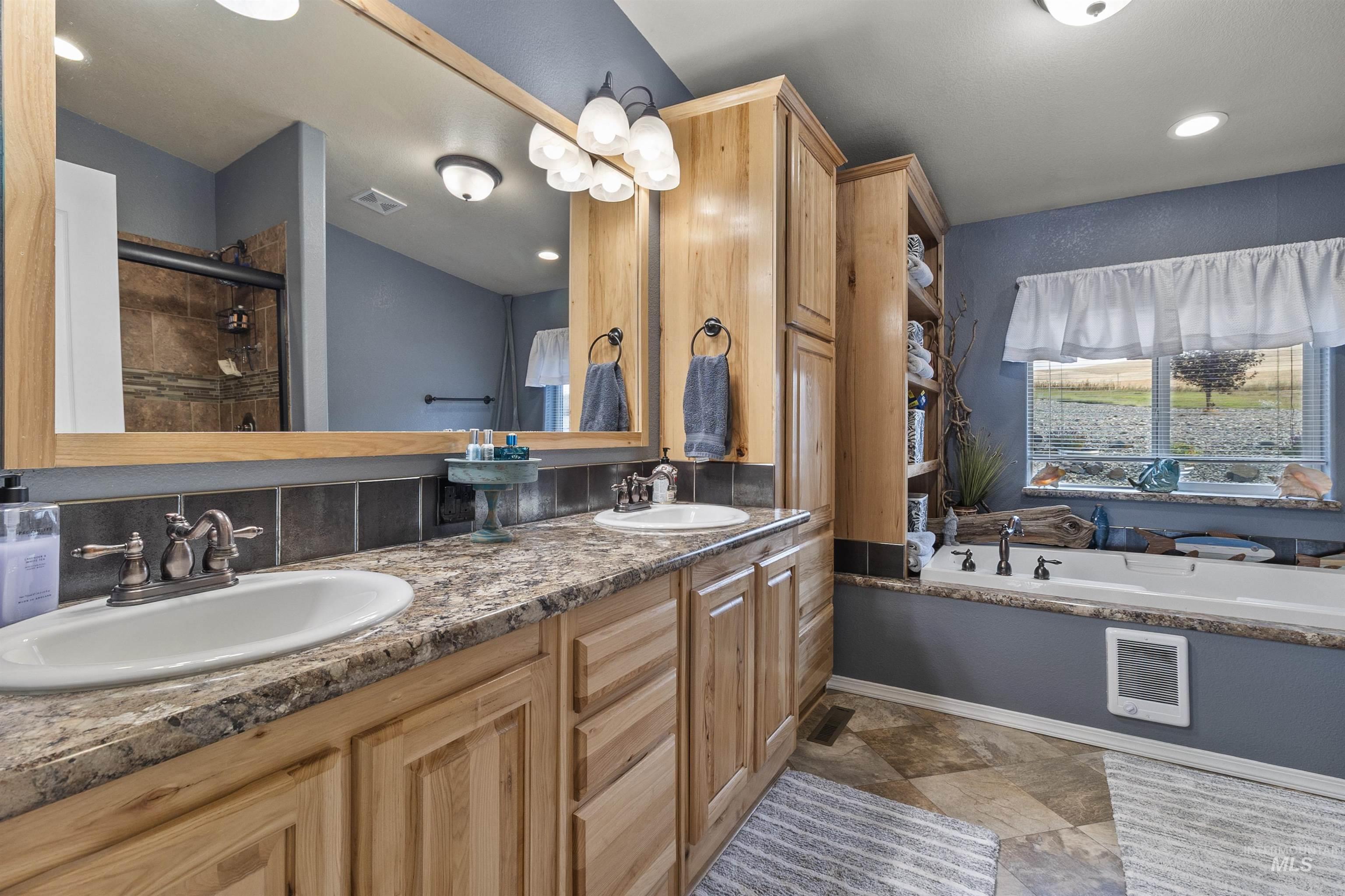 Full bathroom with double vanity, a bath, a tile shower, recessed lighting, and heating unit