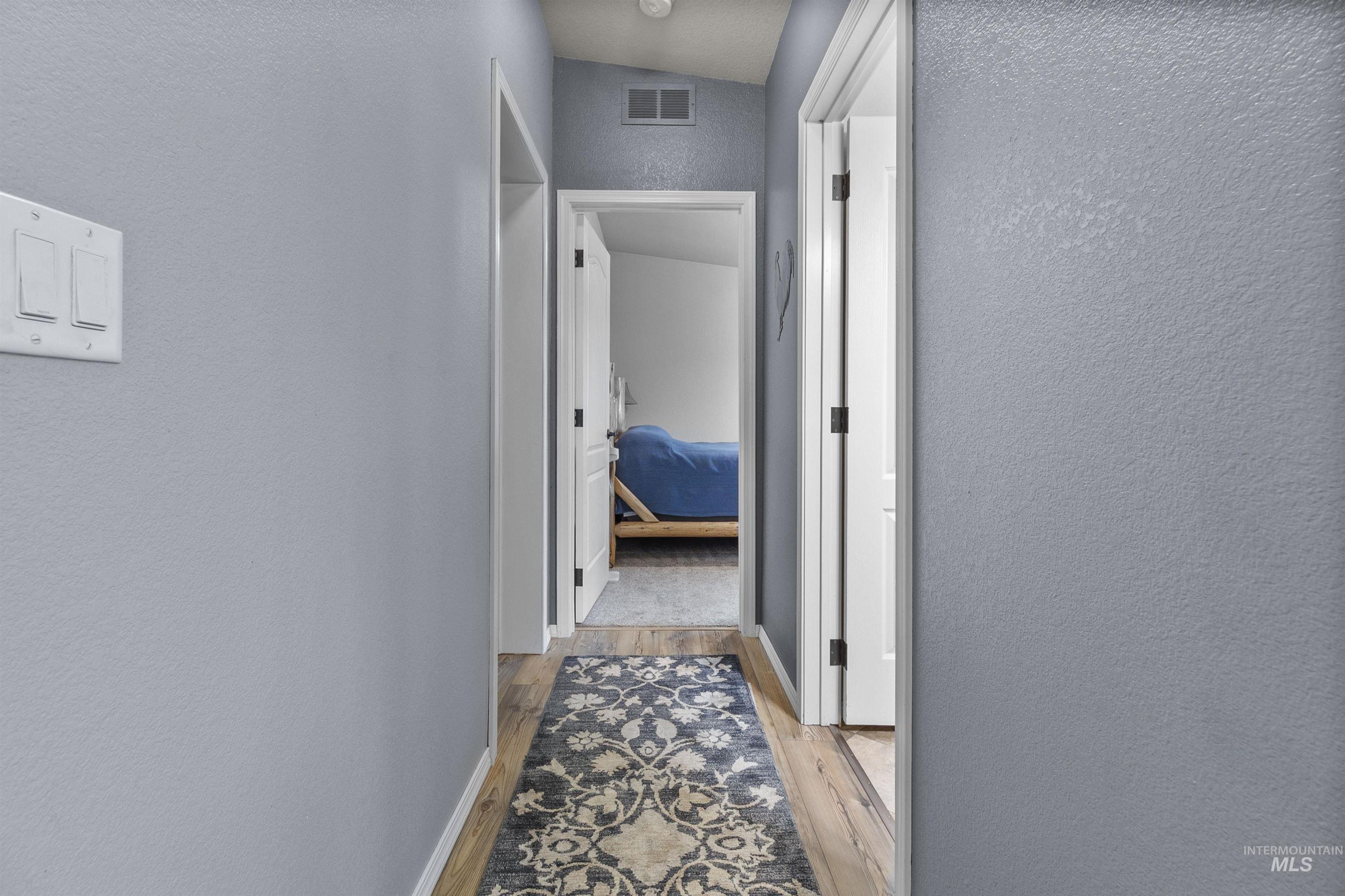 Hall with a textured wall and light wood-style floors
