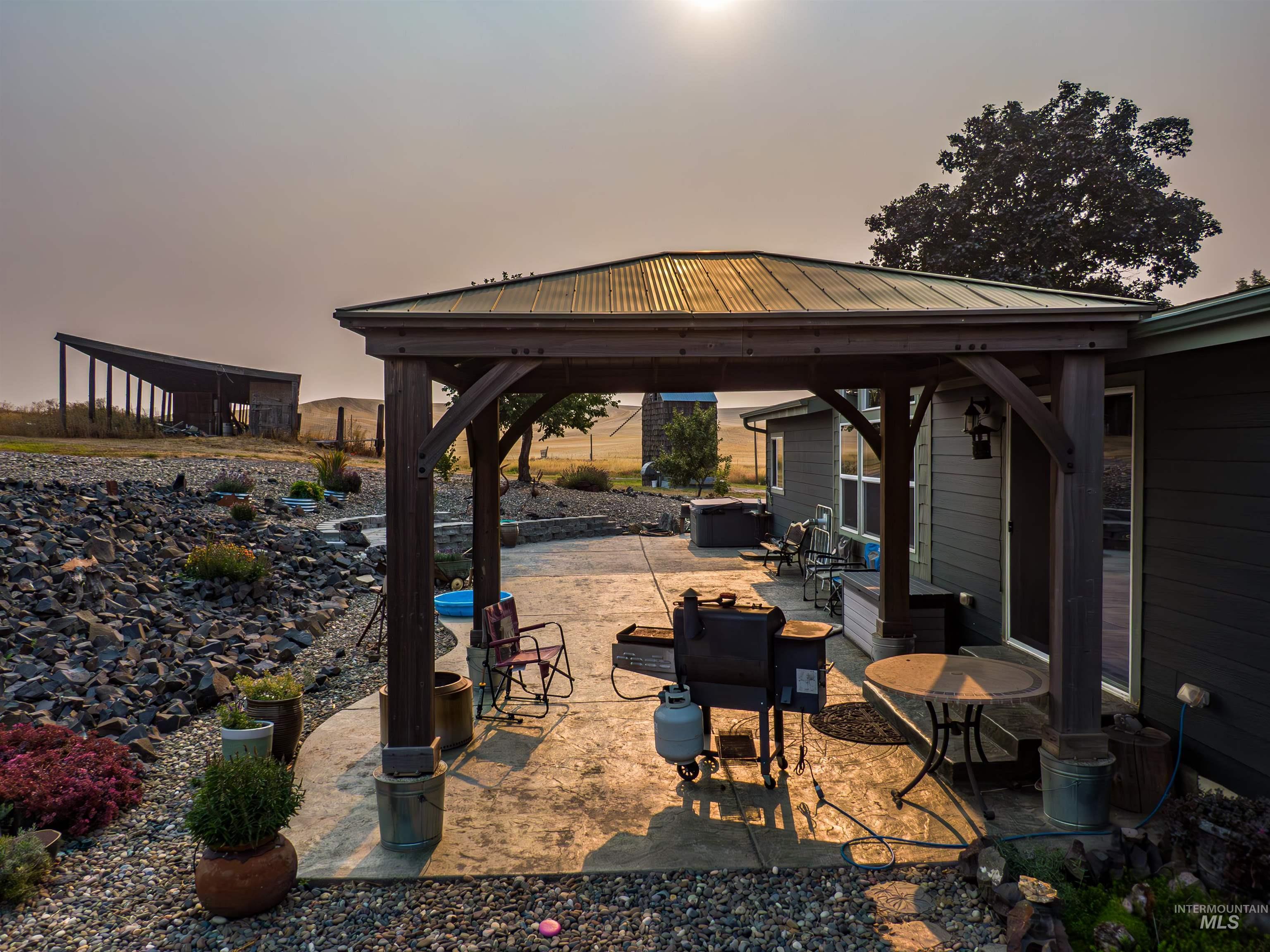 Patio terrace at dusk featuring a patio area and a gazebo