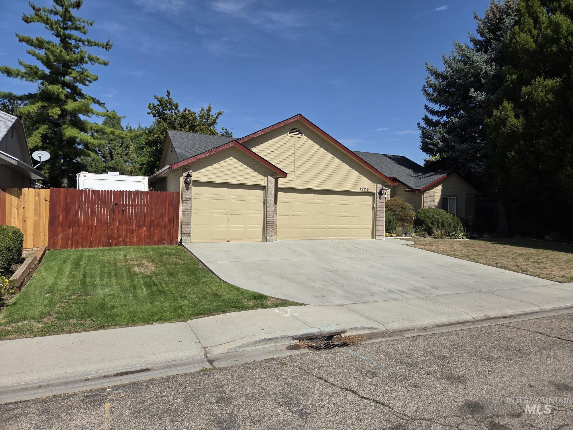 Single story home featuring concrete driveway, brick siding, and a garage