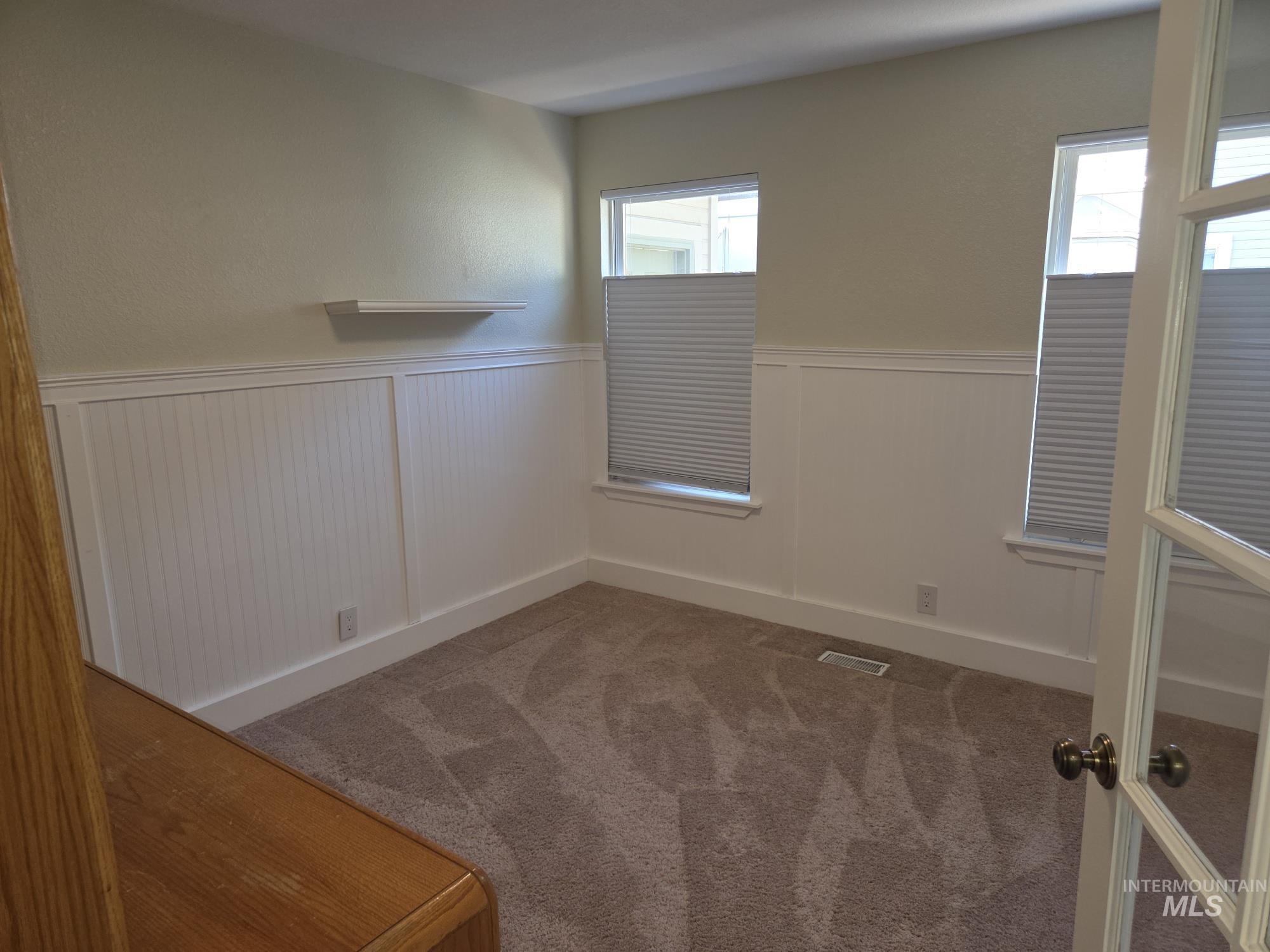 Carpeted empty room with wainscoting