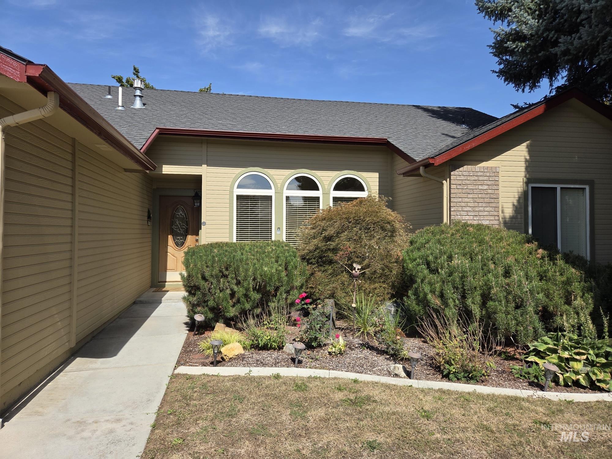 View of exterior entry with roof with shingles
