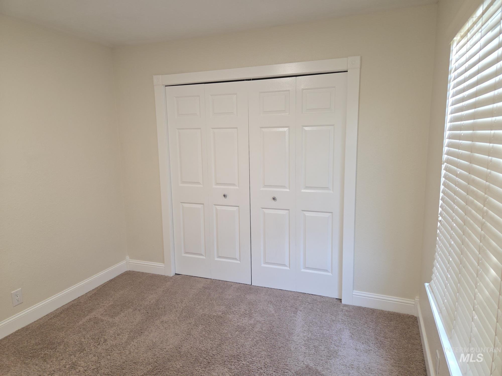Unfurnished bedroom featuring carpet flooring and a closet