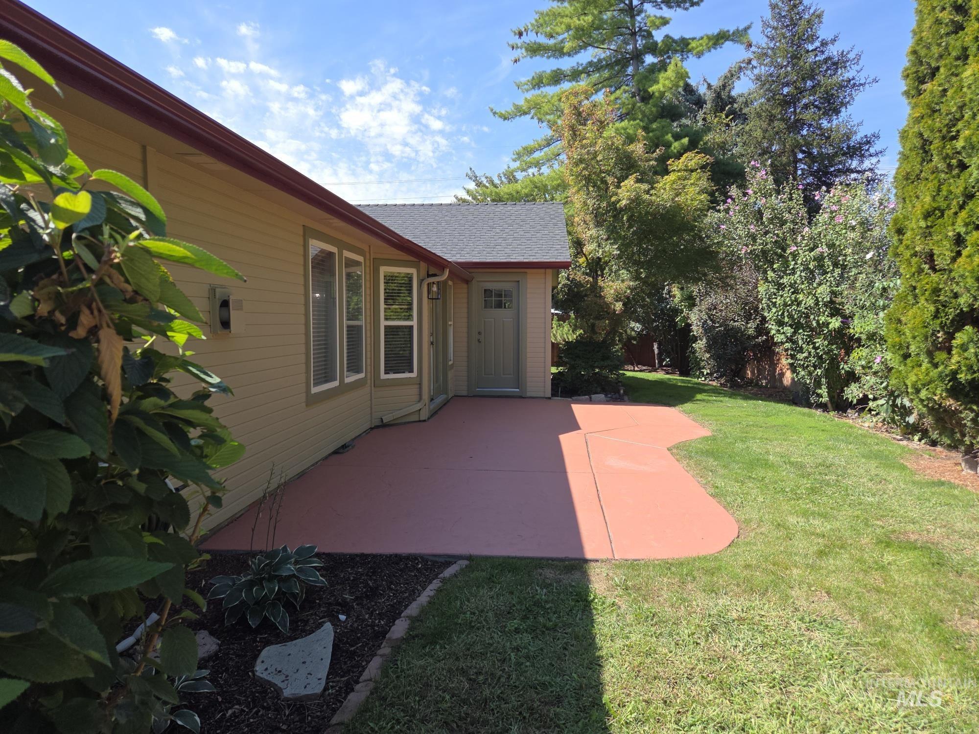 View of grassy yard featuring a patio area