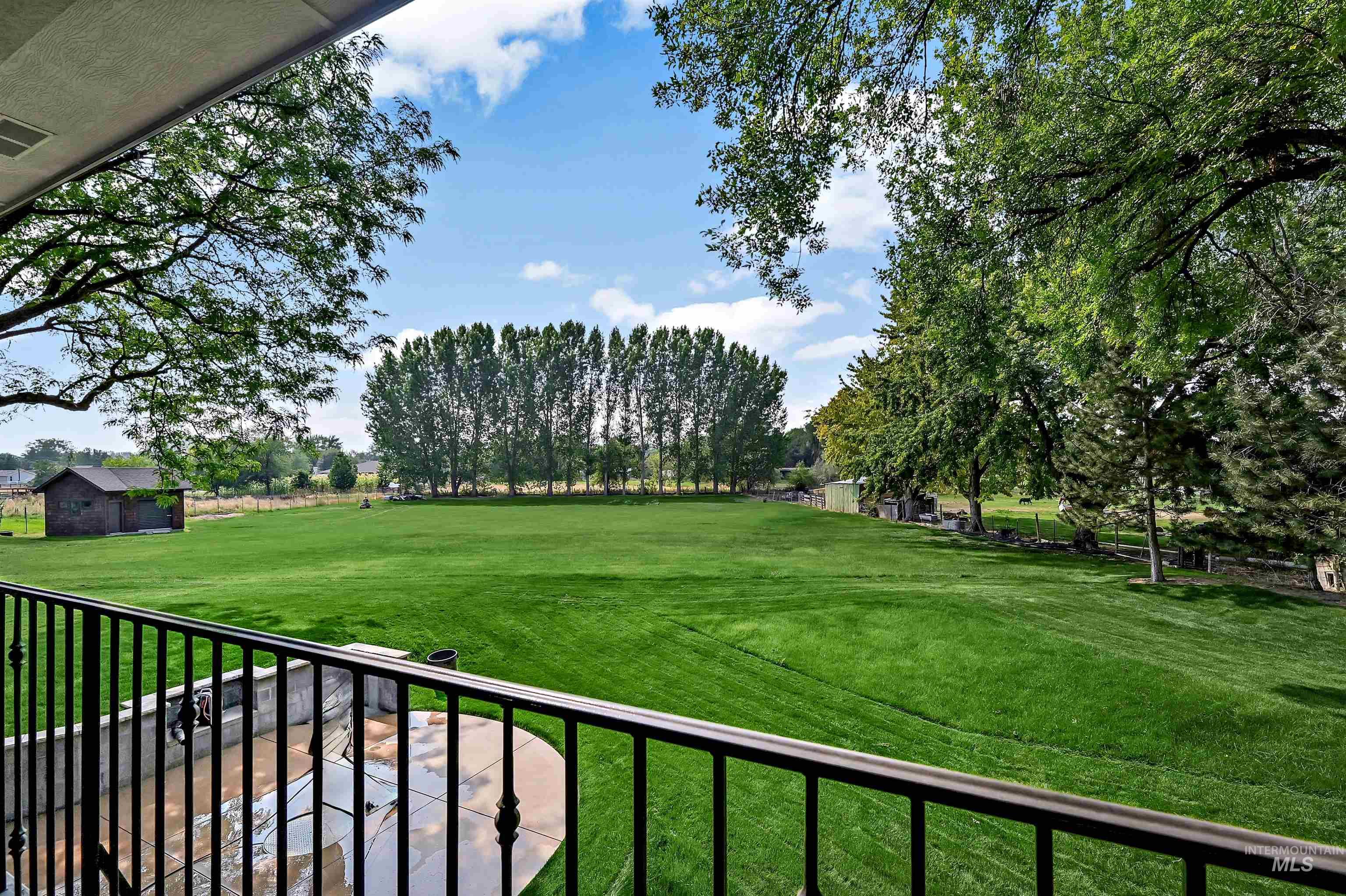 View of grassy yard featuring a balcony
