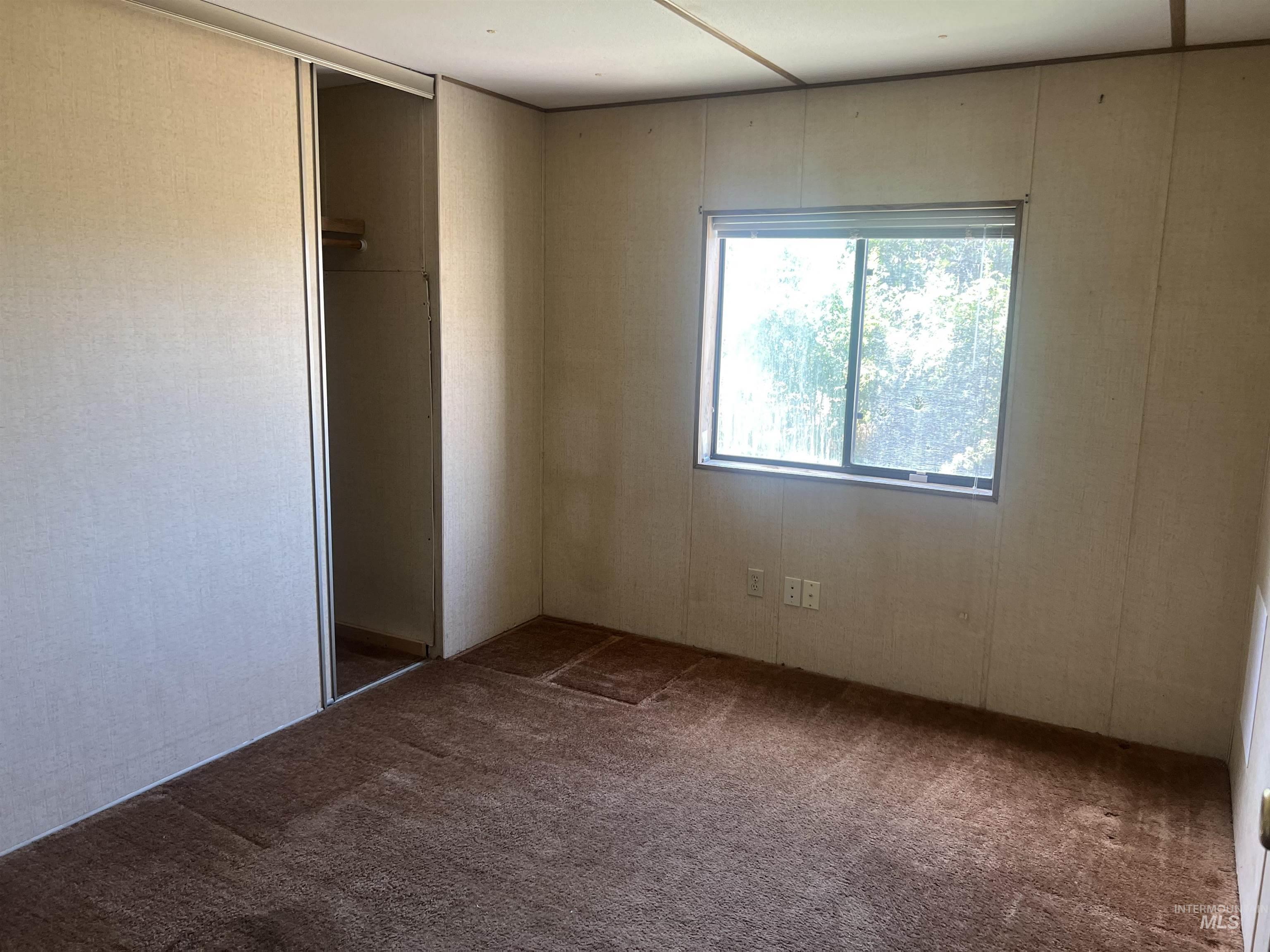 Unfurnished bedroom featuring dark colored carpet and a closet