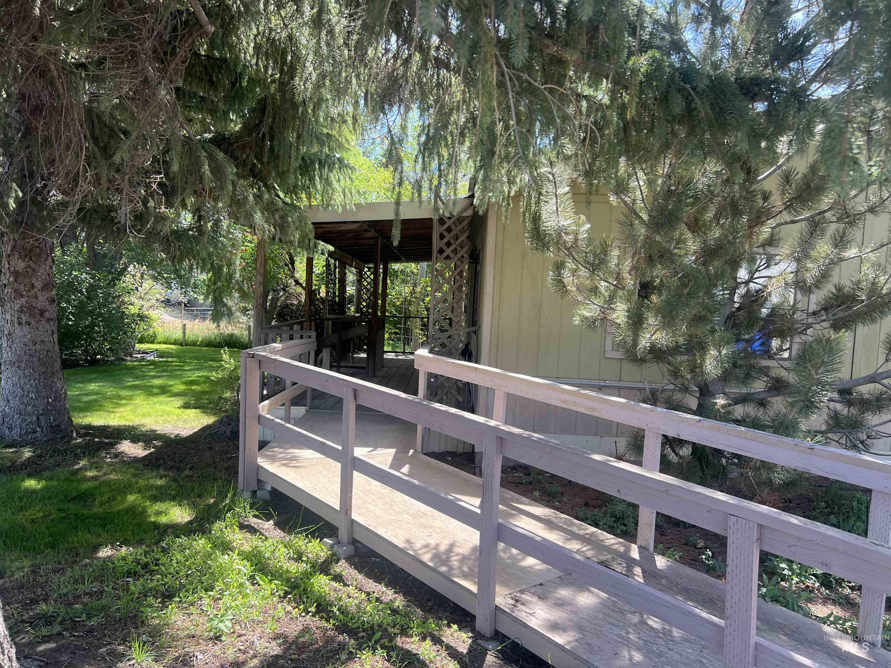 View of green lawn with a wooden deck