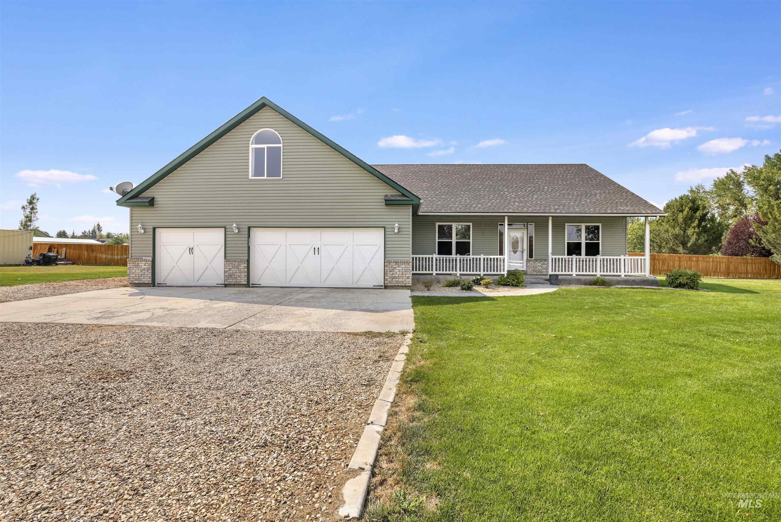 View of front facade featuring covered porch, driveway, roof with shingles, and brick siding