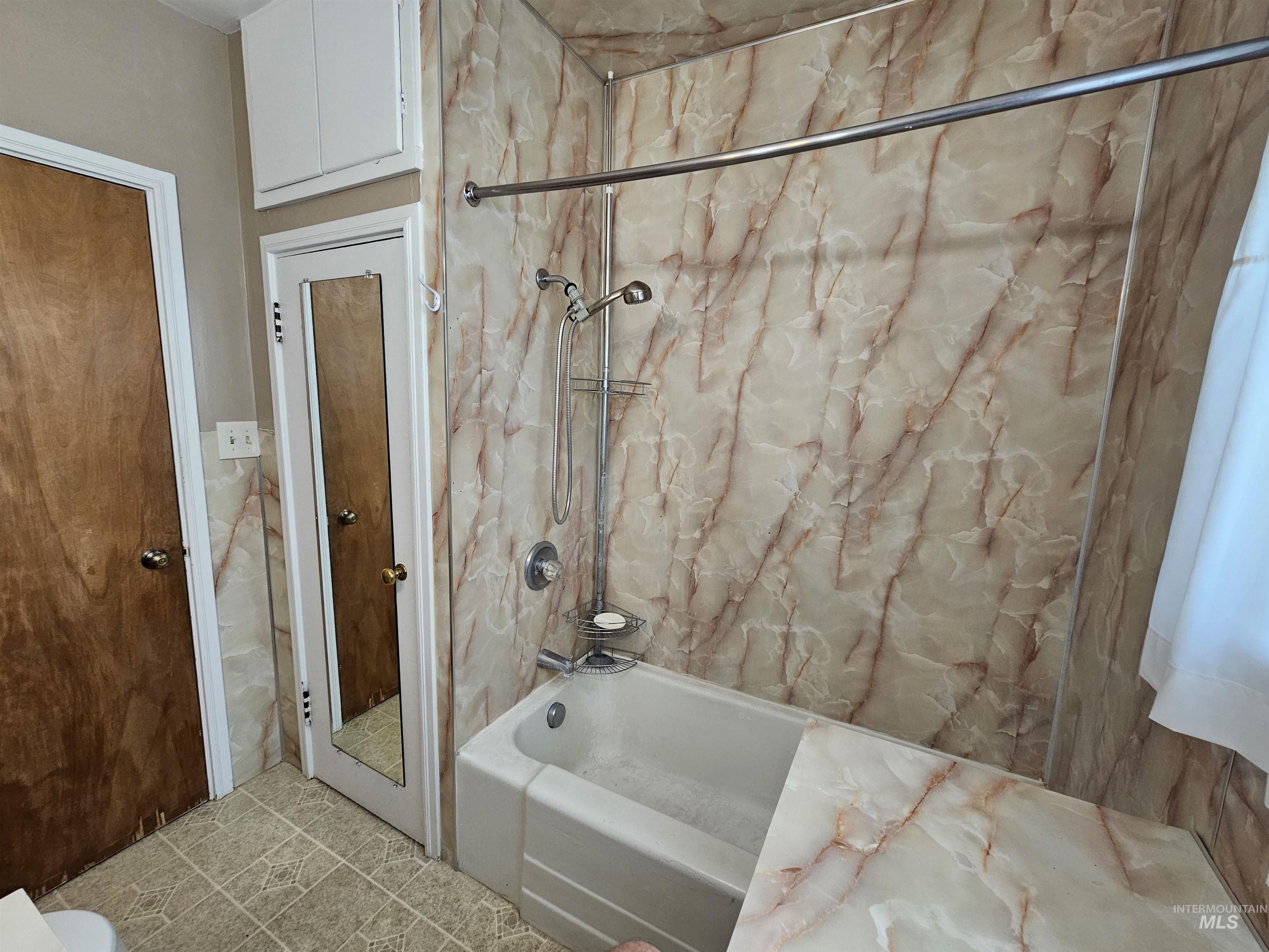 Bathroom featuring  shower combination and tile patterned flooring