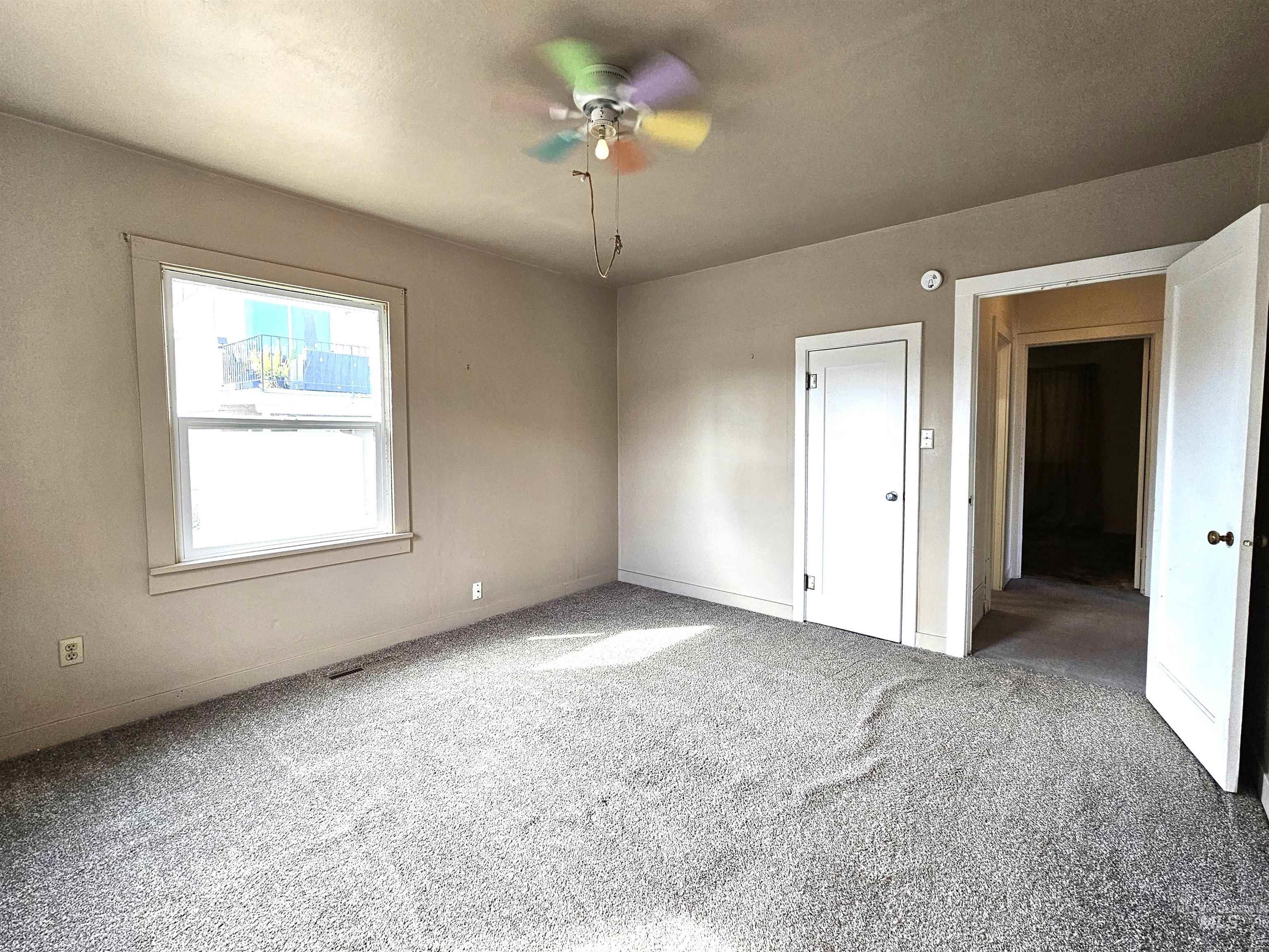 Unfurnished bedroom with carpet and a ceiling fan