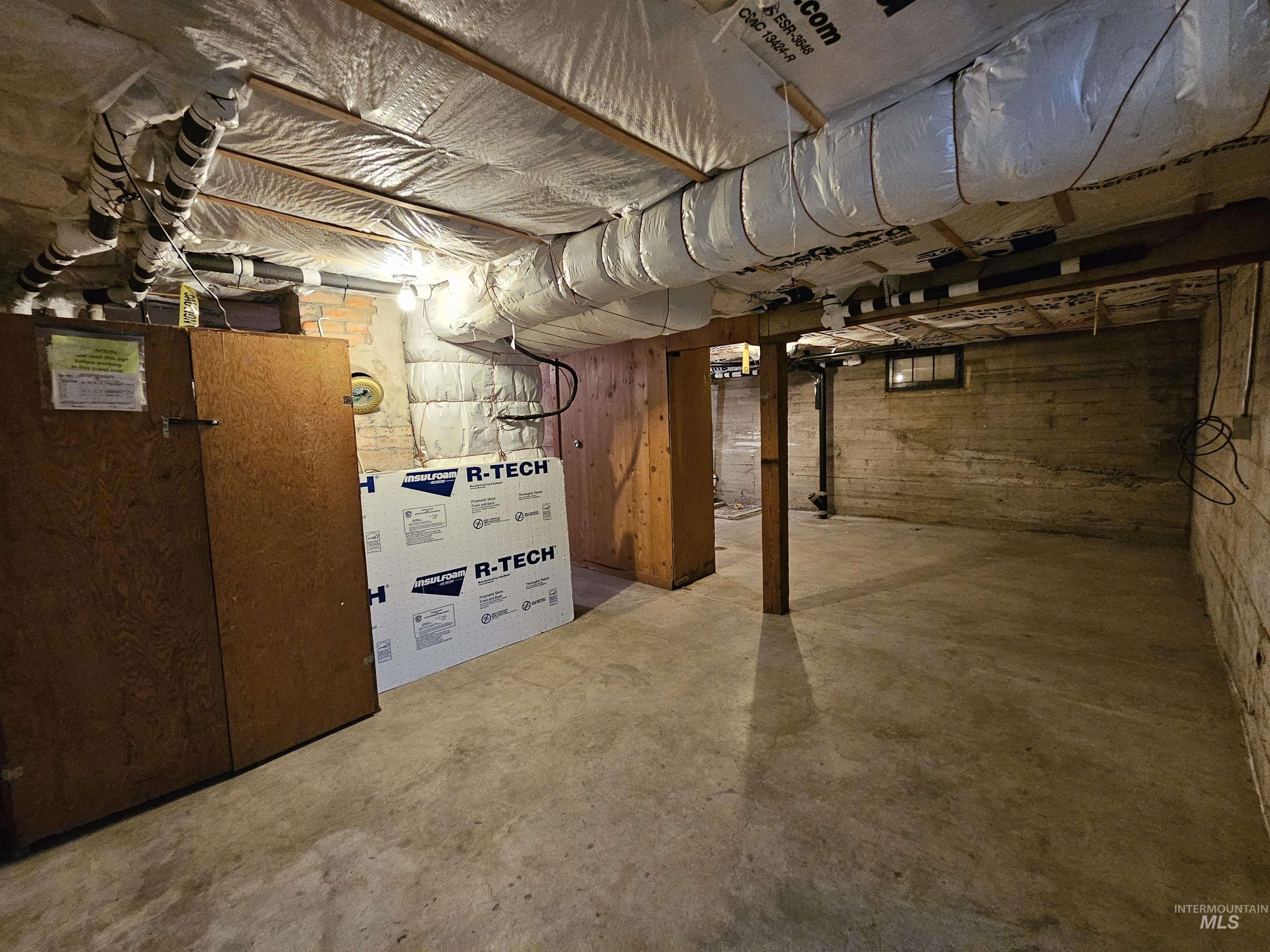 Unfinished below grade area featuring heating unit