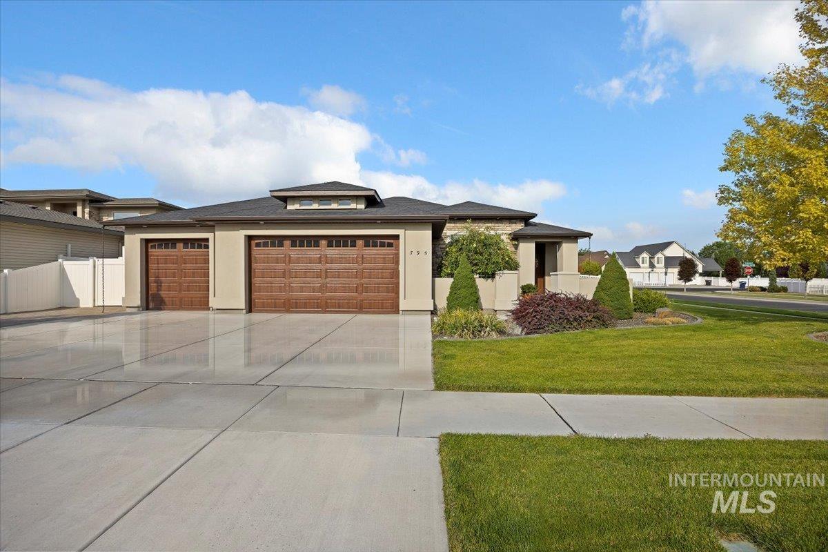 Prairie-style home with a garage, stucco siding, and concrete driveway
