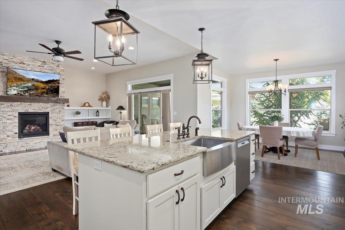 Kitchen featuring a chandelier, a kitchen breakfast bar, white cabinetry, and light stone countertops