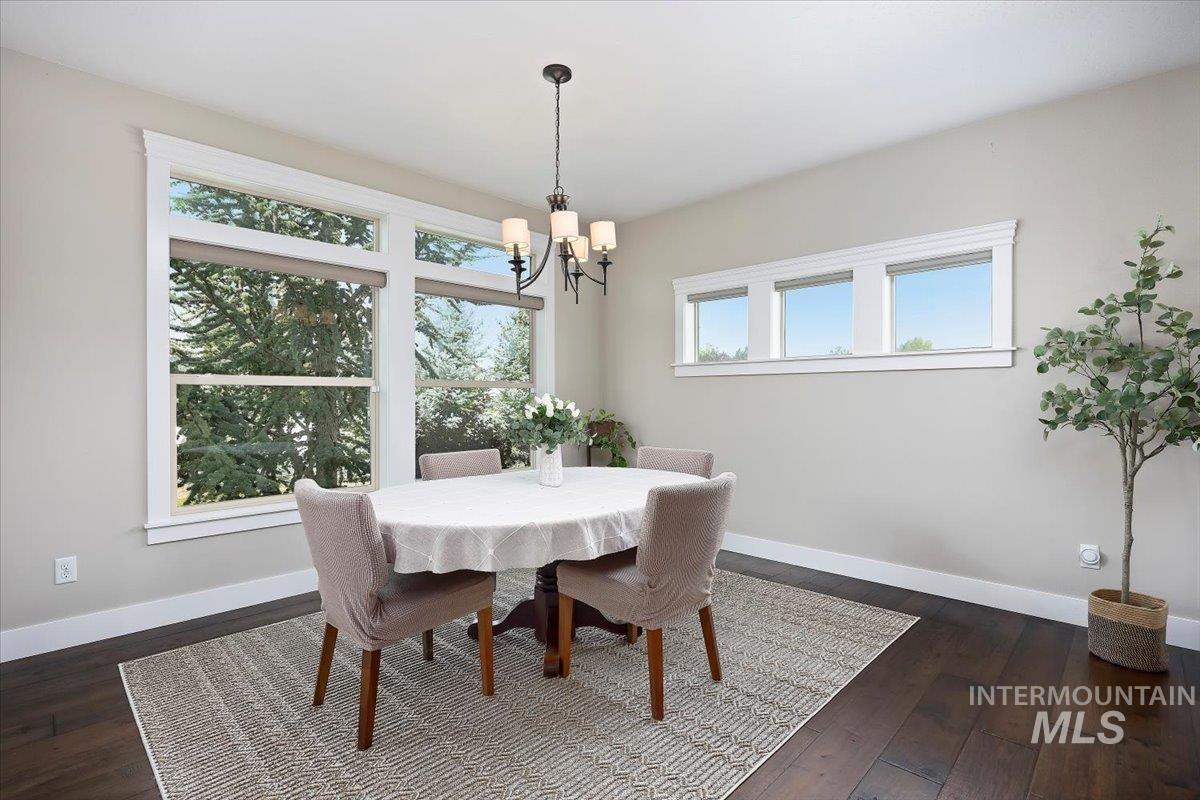 Dining room featuring dark wood finished floors and a chandelier