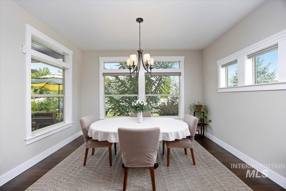 Dining area featuring dark wood-style floors and a chandelier