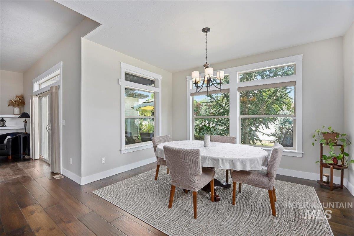 Dining area with dark wood finished floors and a chandelier
