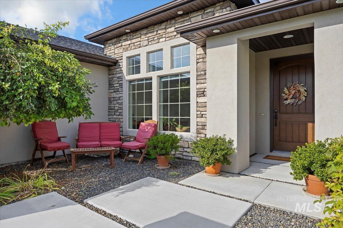 Doorway to property featuring stone siding and stucco siding