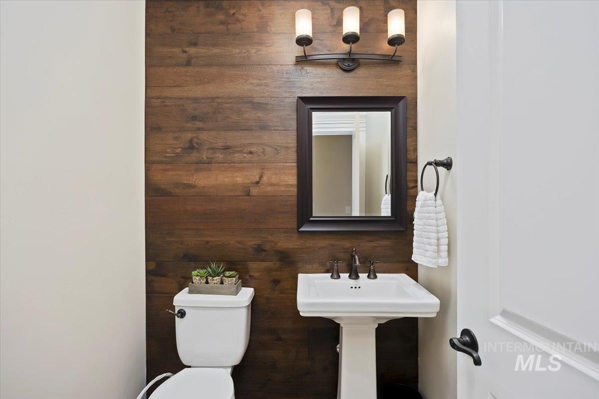 Bathroom featuring toilet and wood walls