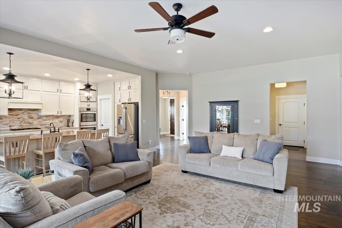 Living room featuring recessed lighting, dark wood finished floors, and ceiling fan