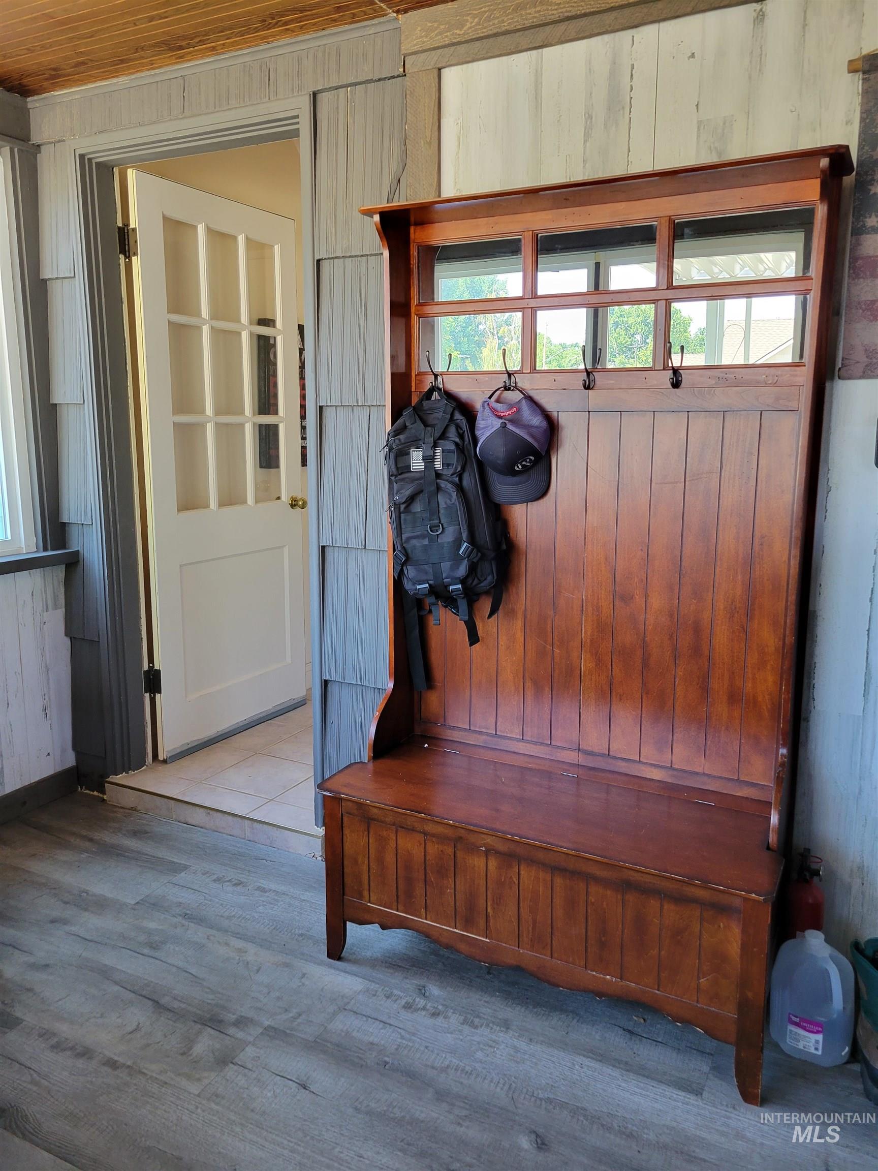 Mudroom with wood walls, wood finished floors, and plenty of natural light