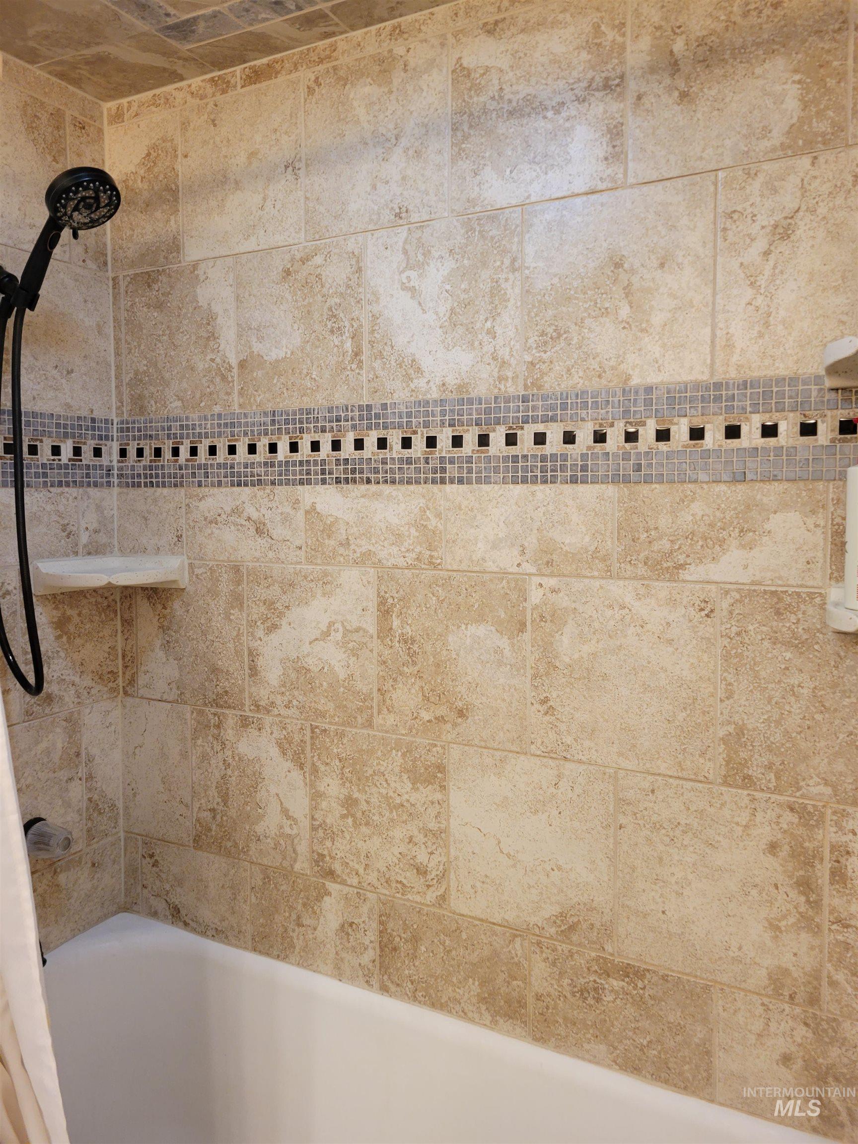 Bathroom view of tiled shower / bath combo
