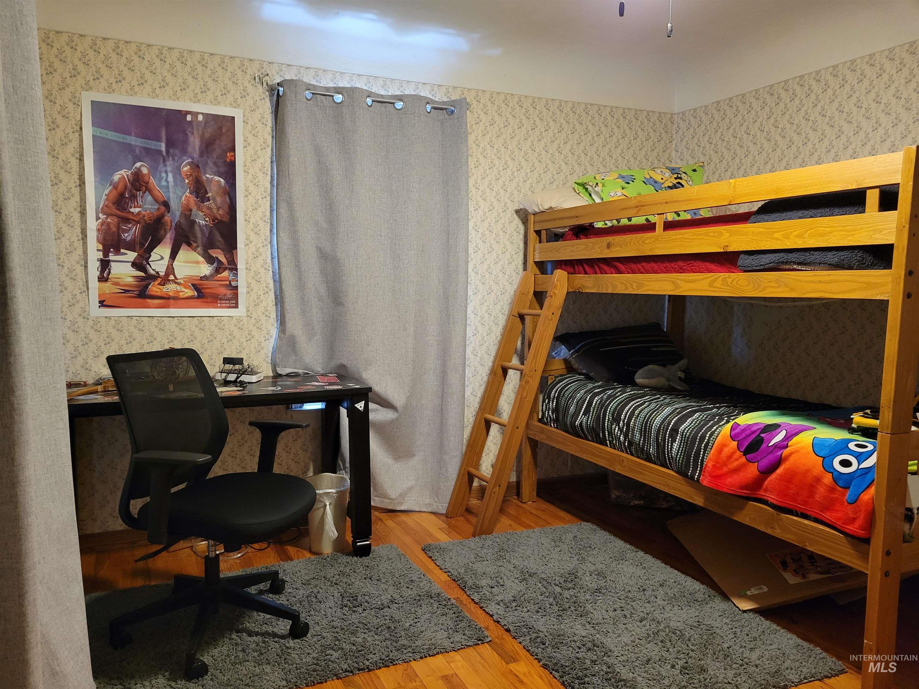 Bedroom featuring light wood-style floors and wallpapered walls