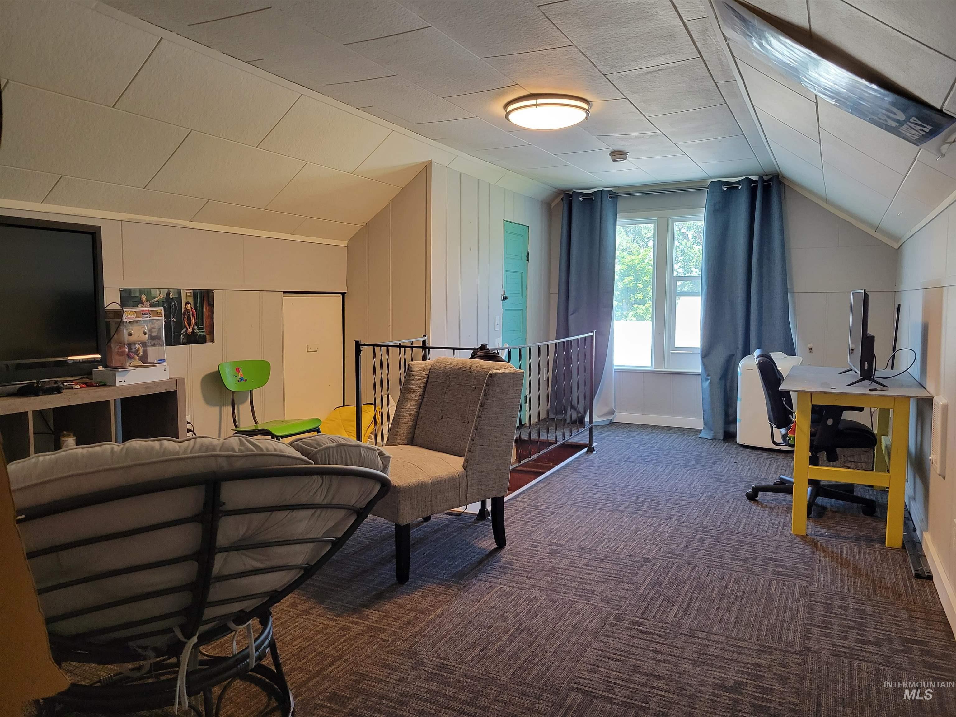 Additional living space featuring lofted ceiling, carpet floors, and an office area