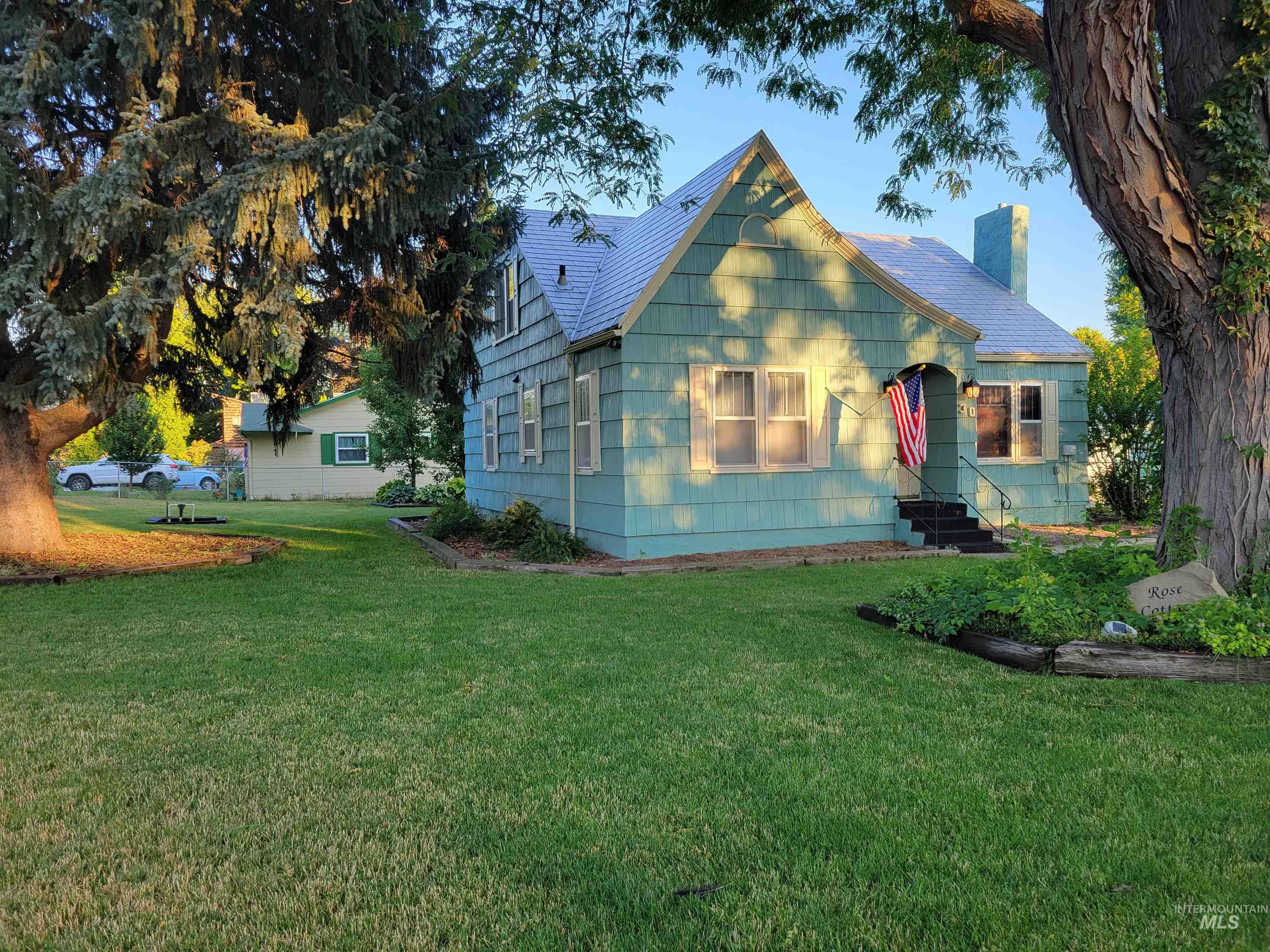 View of front facade with a chimney and a front lawn