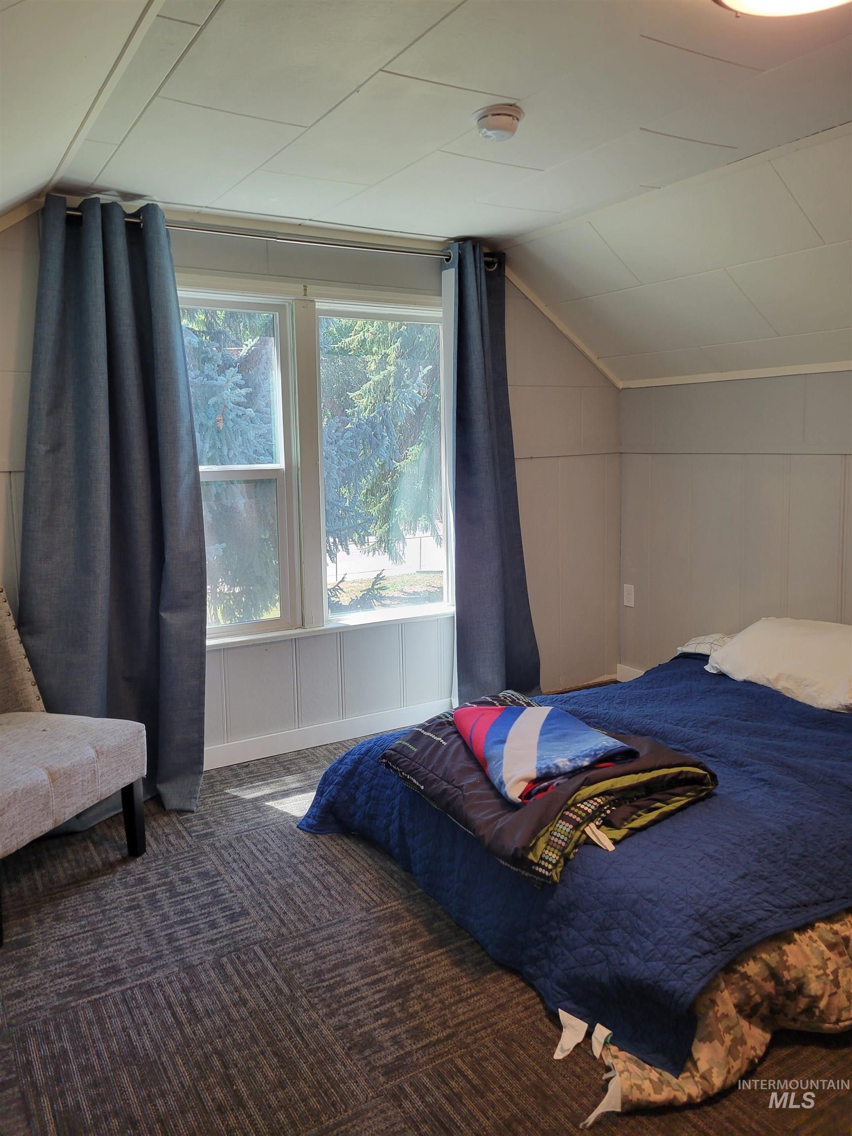 Bedroom featuring vaulted ceiling and carpet flooring