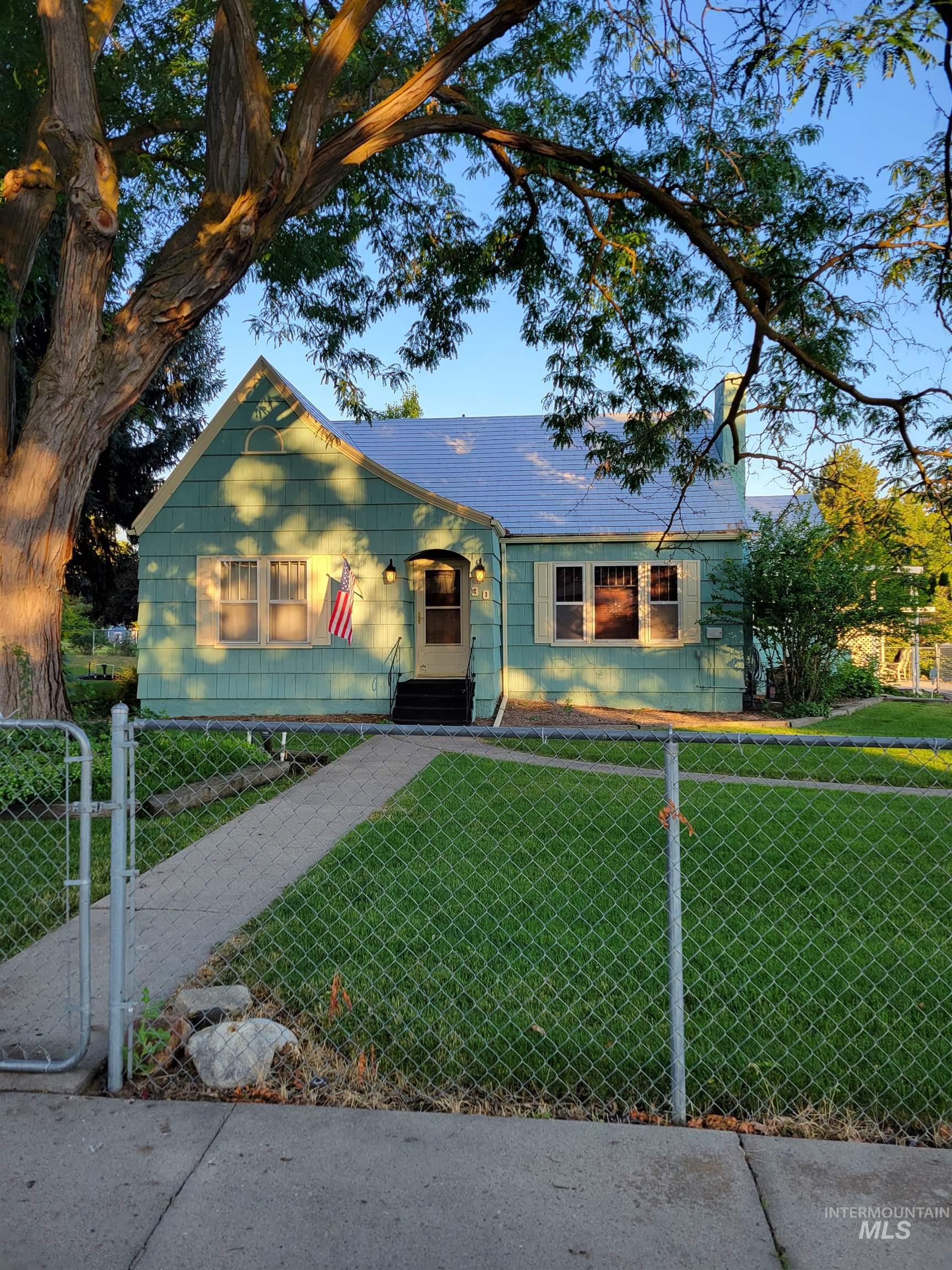 View of front facade featuring a fenced front yard, a gate, and a chimney
