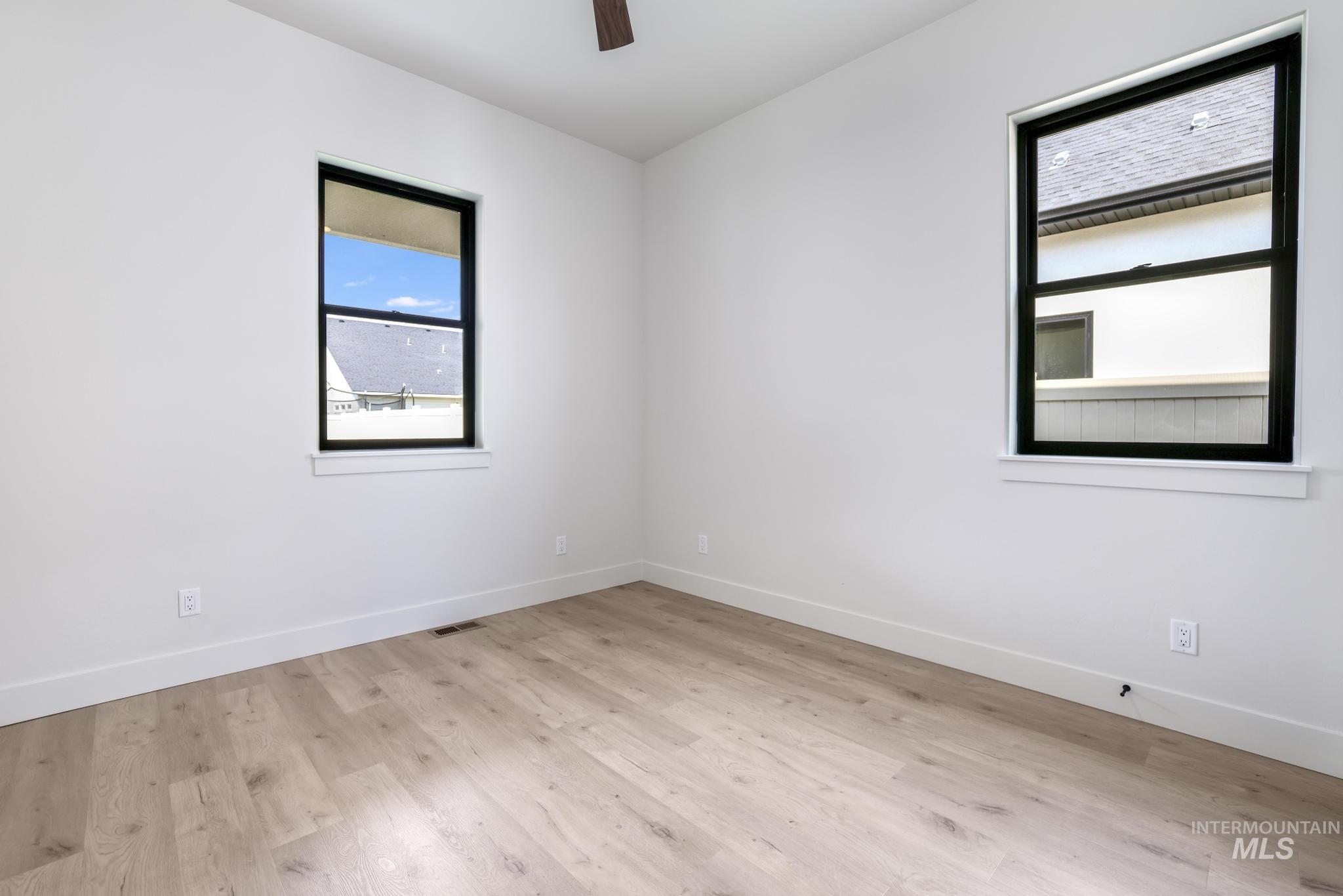Unfurnished room featuring light wood-type flooring and ceiling fan