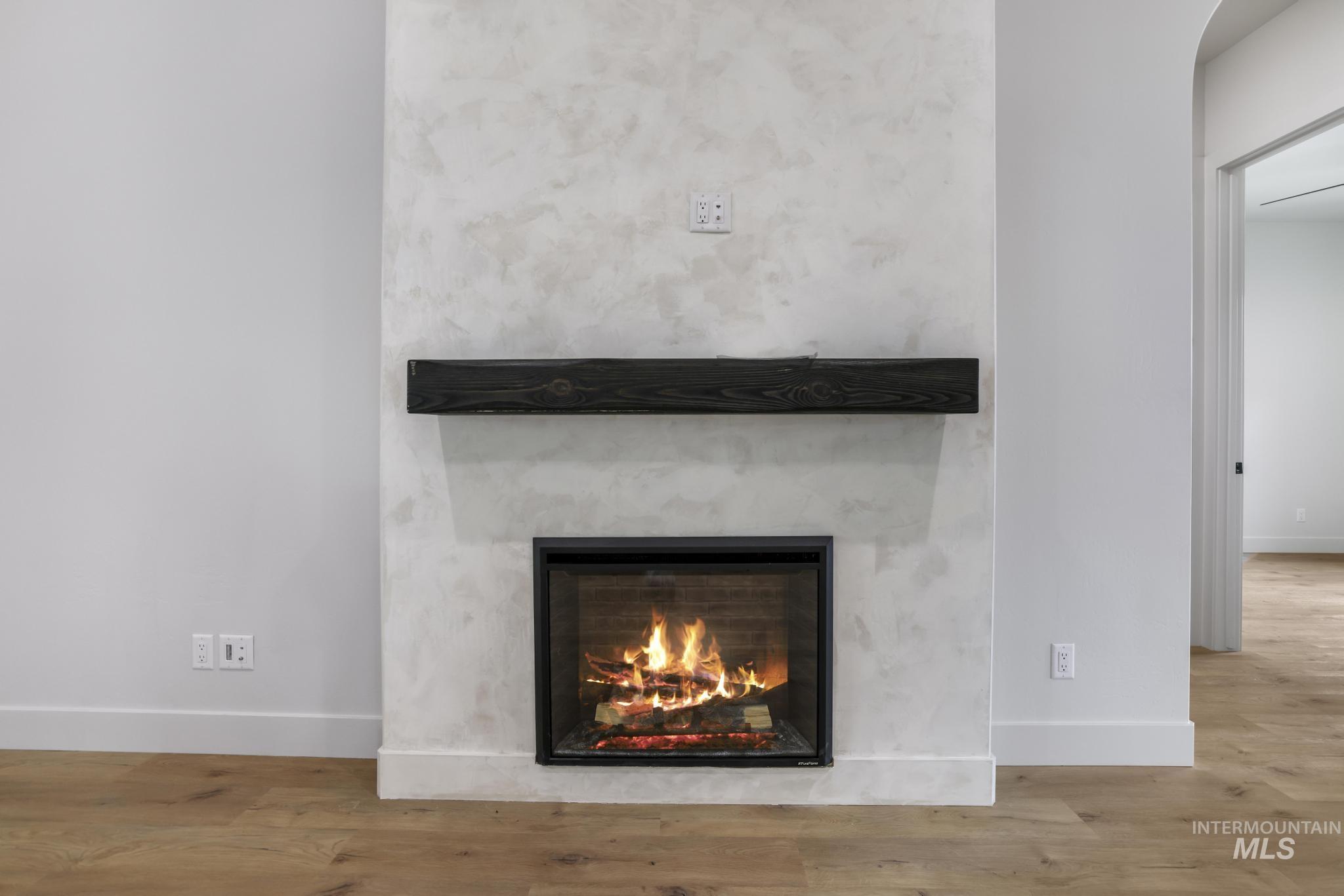 Detailed view of a lit fireplace and wood finished floors
