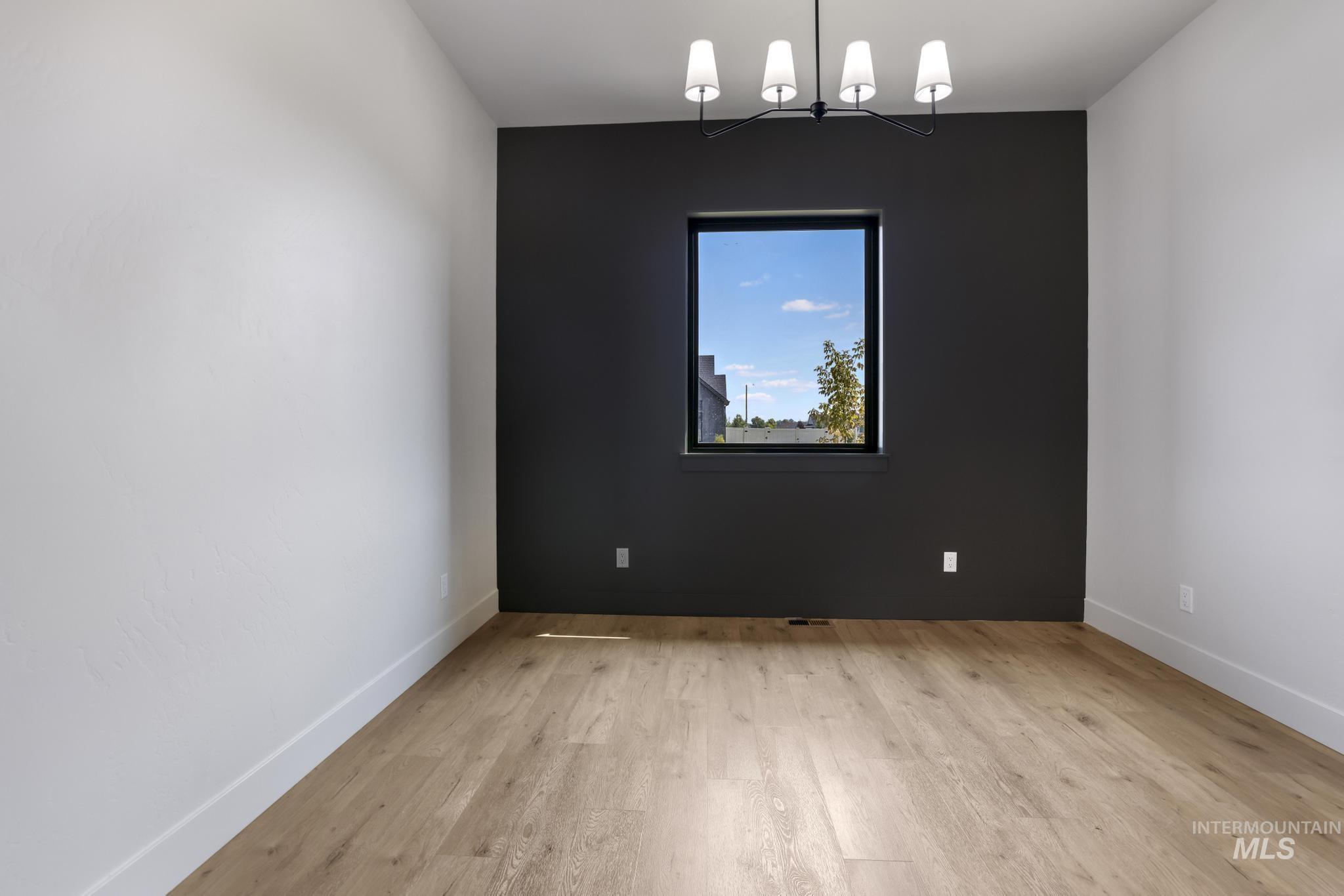 Empty room with light wood finished floors and baseboards