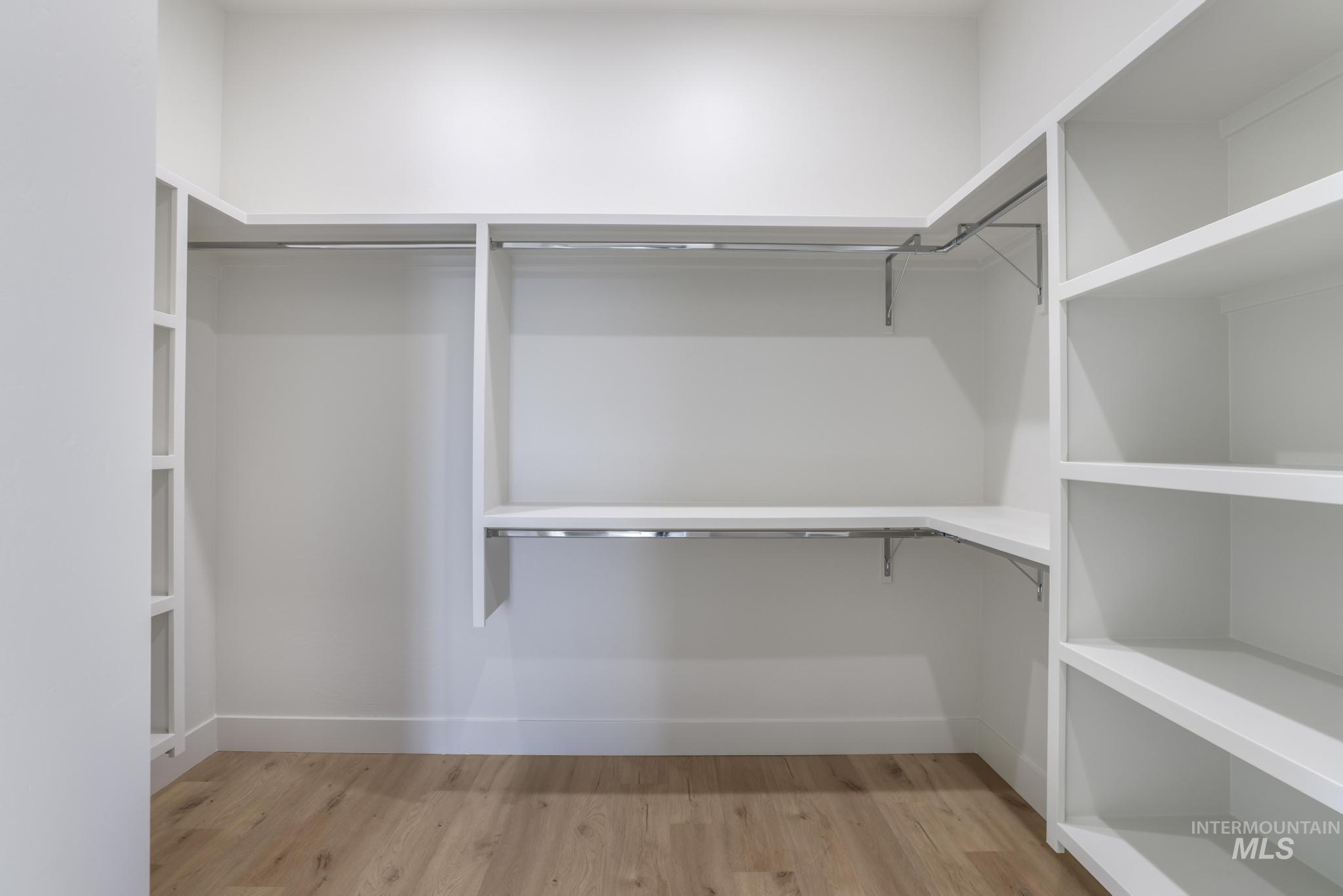 Walk in closet with light wood-style flooring