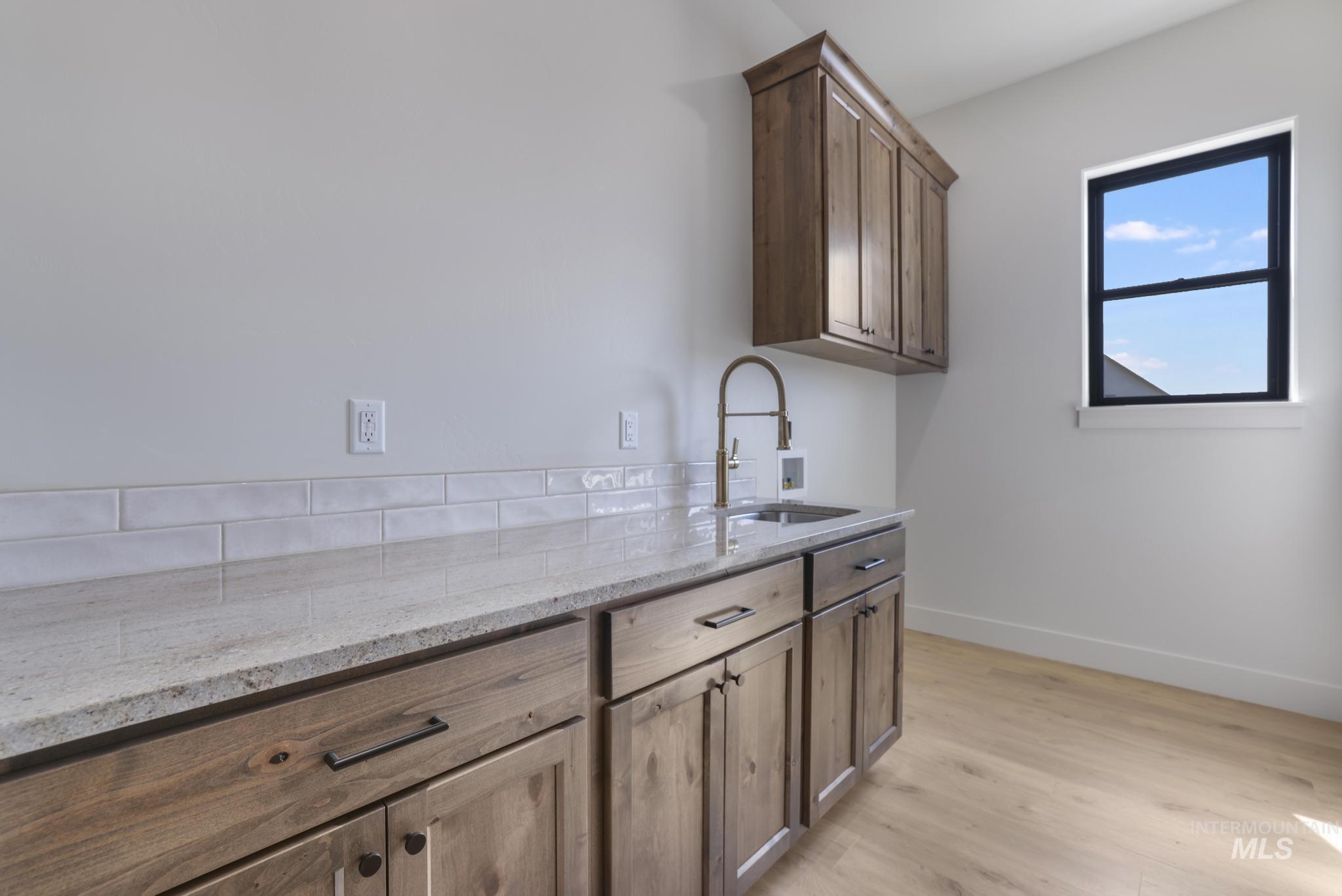Laundry room with light wood-style floors, cabinet space, and hookup for a washing machine