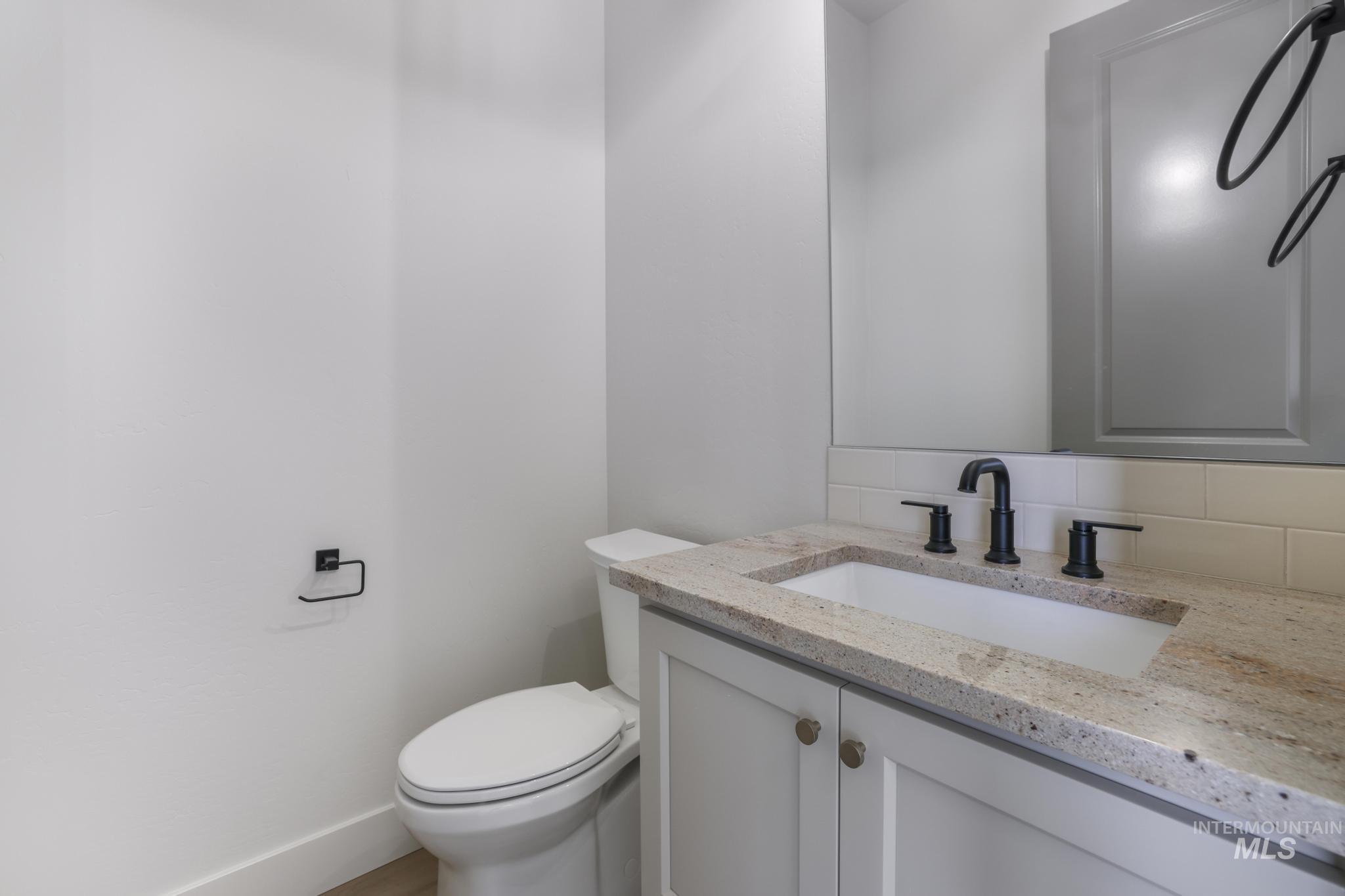 Bathroom featuring vanity and decorative backsplash