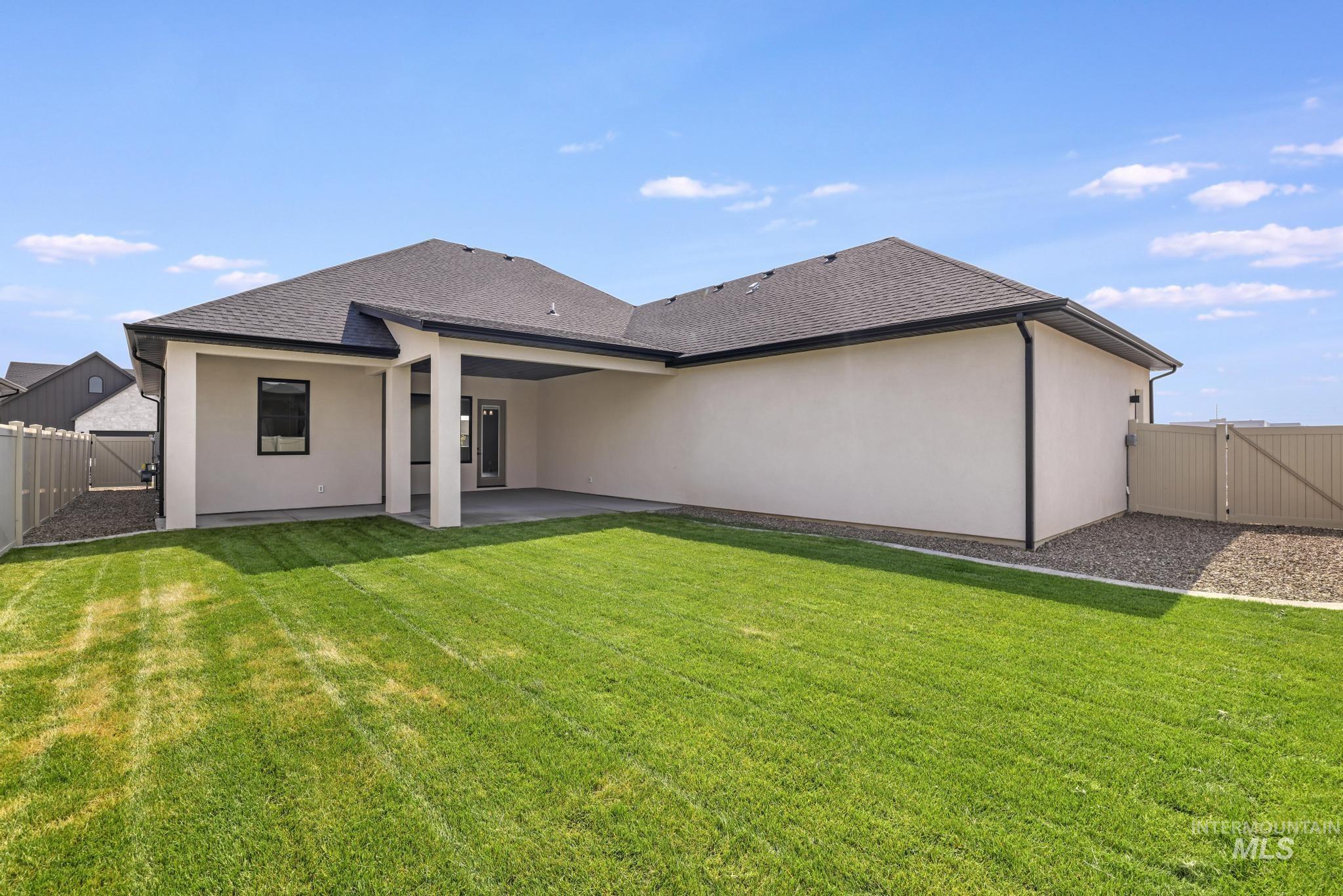 Back of property with a gate, a fenced backyard, a patio, and stucco siding