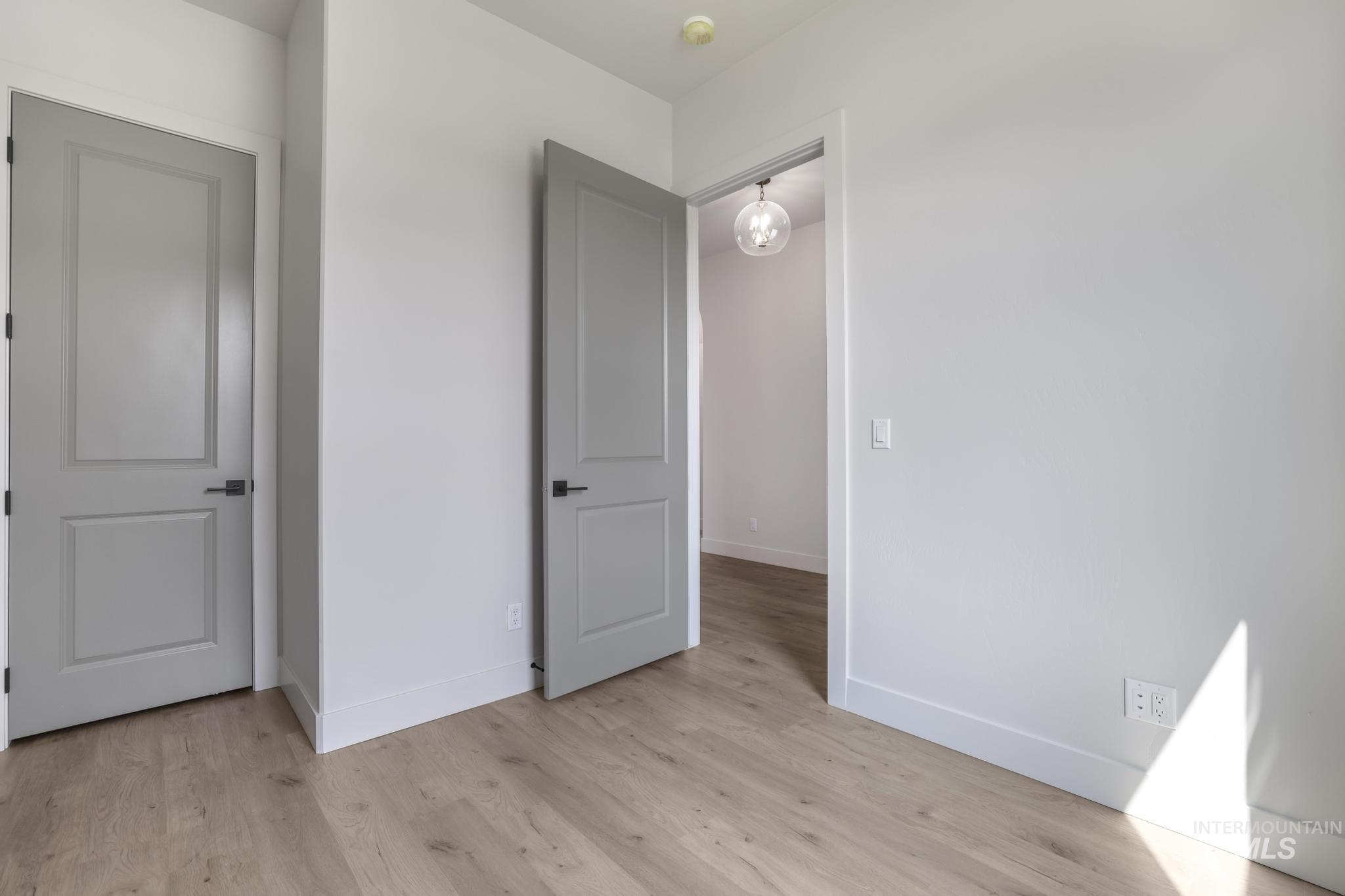 Unfurnished bedroom with baseboards and light wood finished floors
