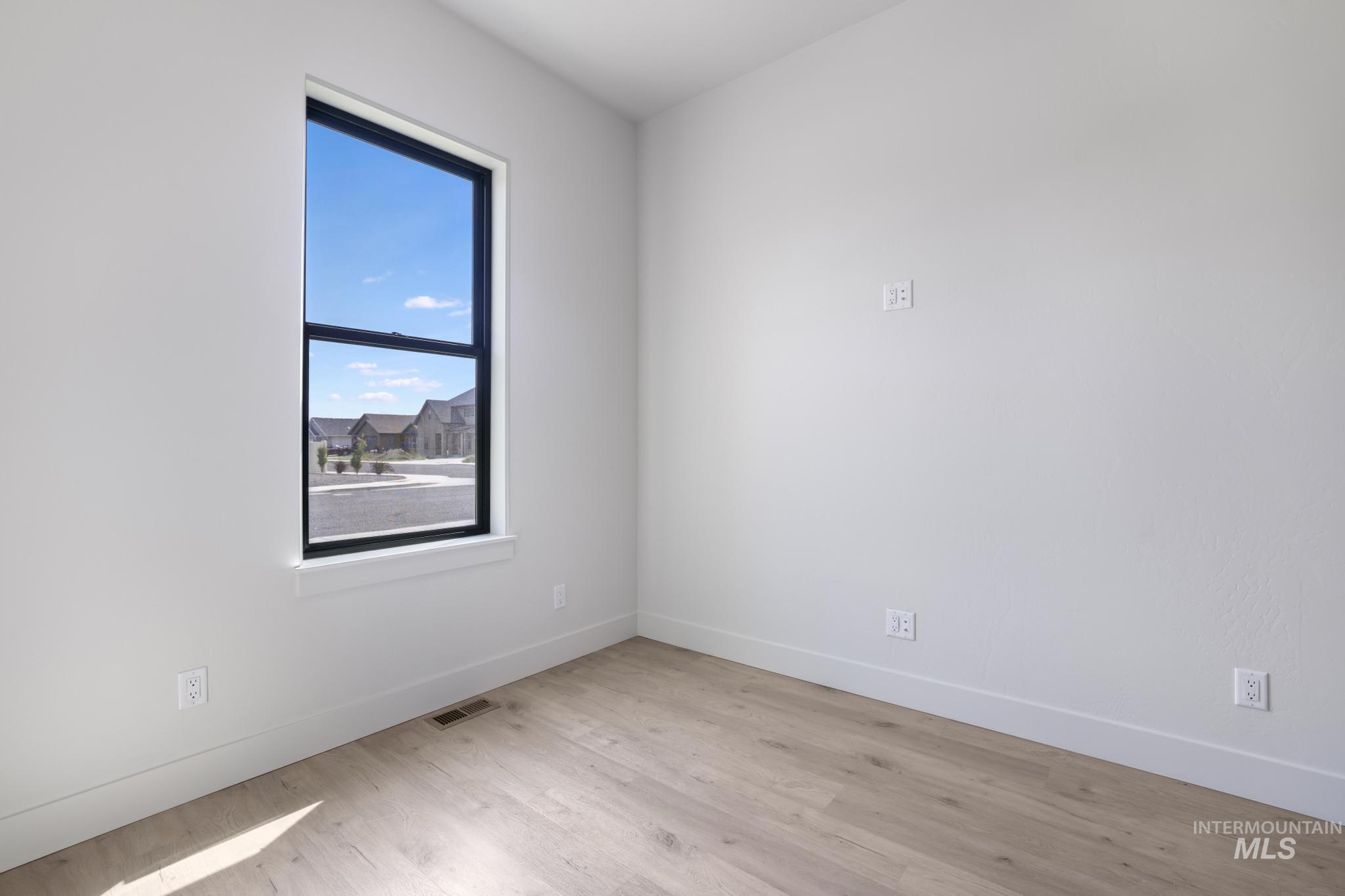 Empty room featuring light wood-type flooring and baseboards