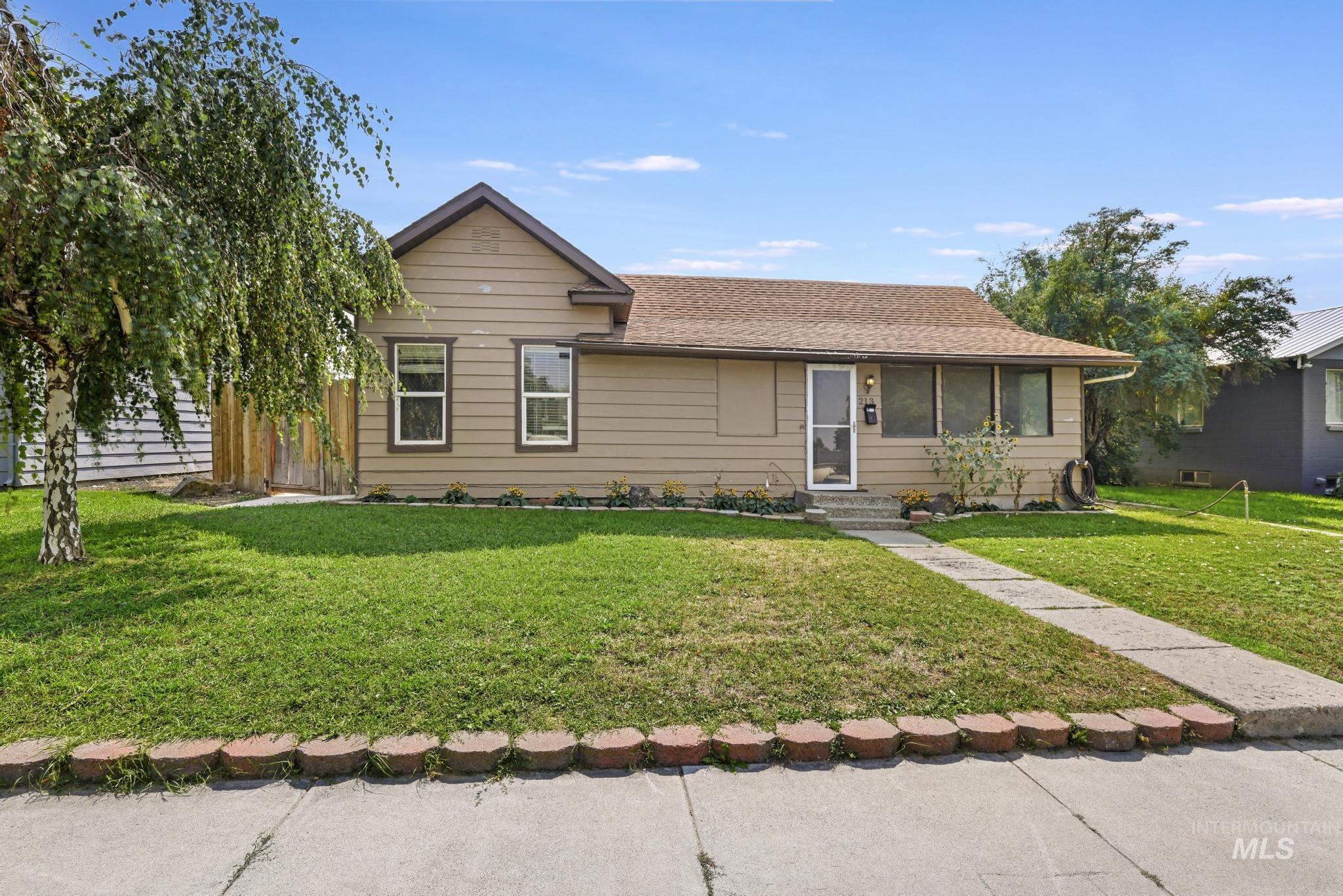 Ranch-style home featuring a shingled roof, a front lawn, and entry steps