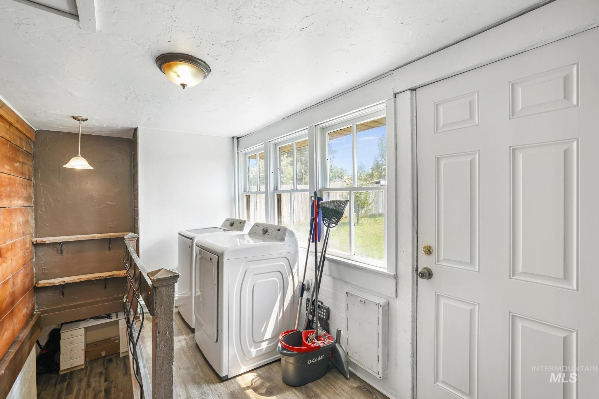 Washroom with separate washer and dryer, wood finished floors, and a textured ceiling